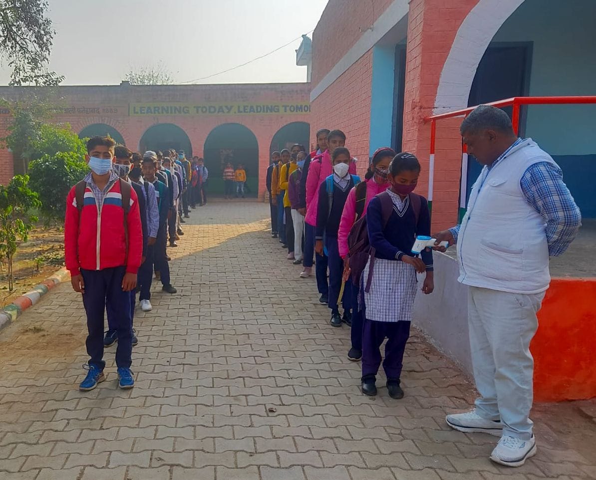 फतेहाबाद के राजकीय स्कूल में विद्यार्थियों की थर्मल स्क्रीनिंग करते शिक्षक।