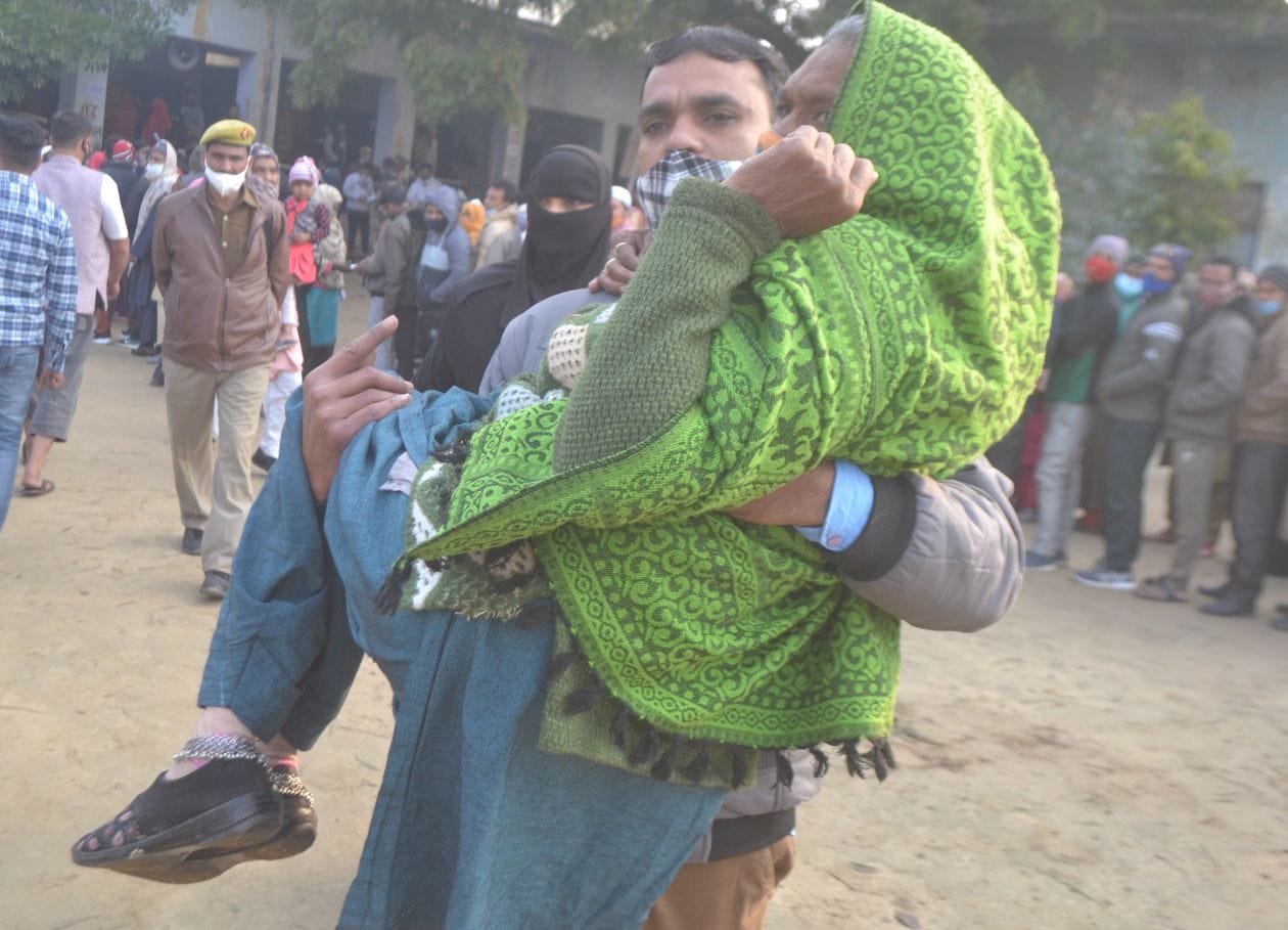 हापुड़ ः वृद्ध महिला को गोद में उठाकर मतदान कराने ले जाता युवक - संवाद