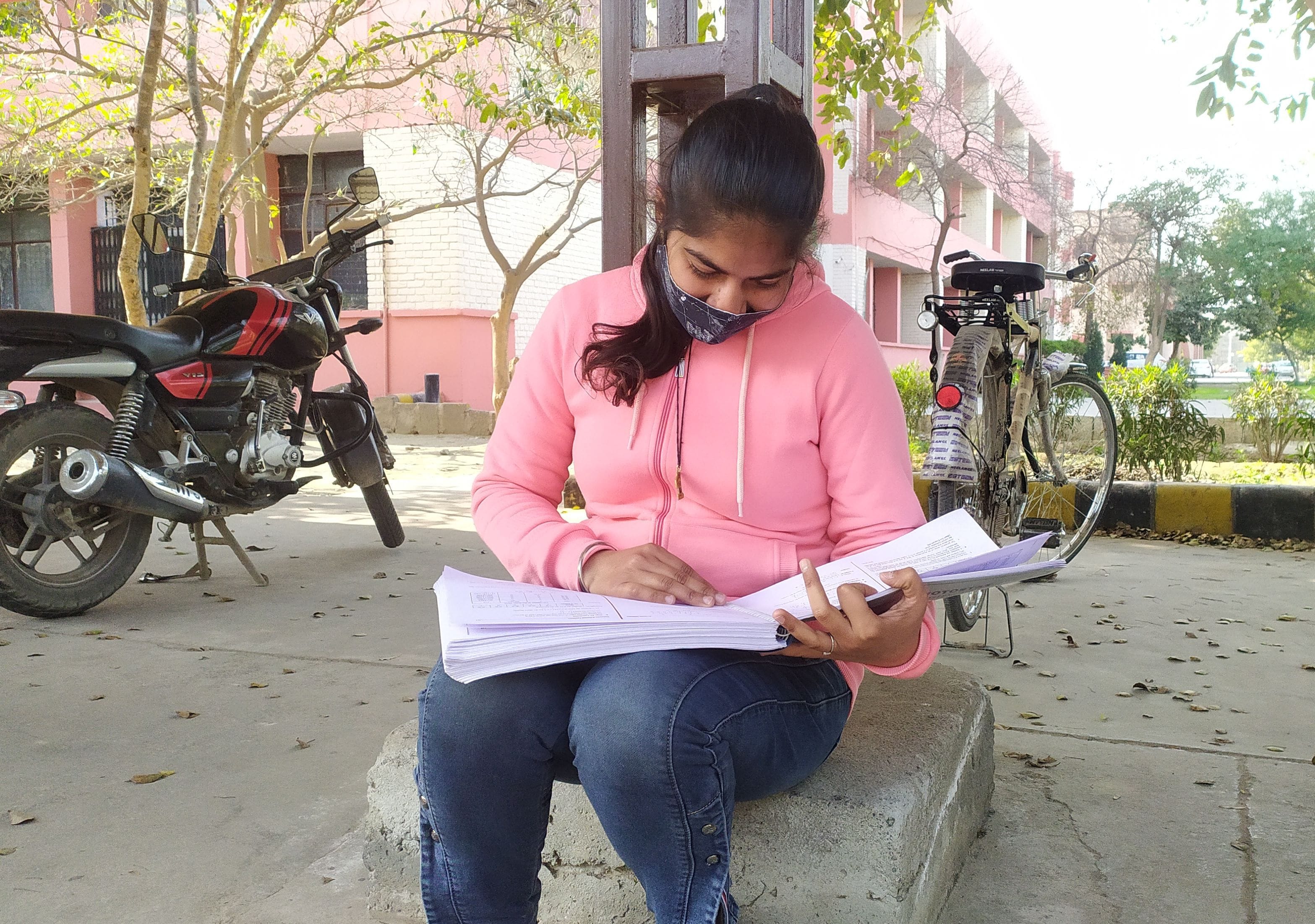 परीक्षा से पहले नोटस पढ़ती छात्रा ।