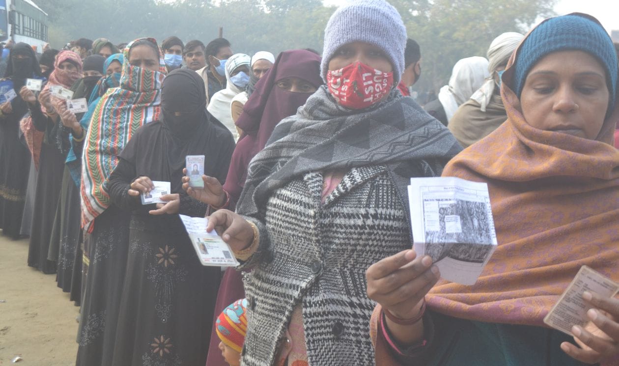 मतदान करने के  लिए अपना आधार कार्ड दिखाती महिलाएं - संवाद