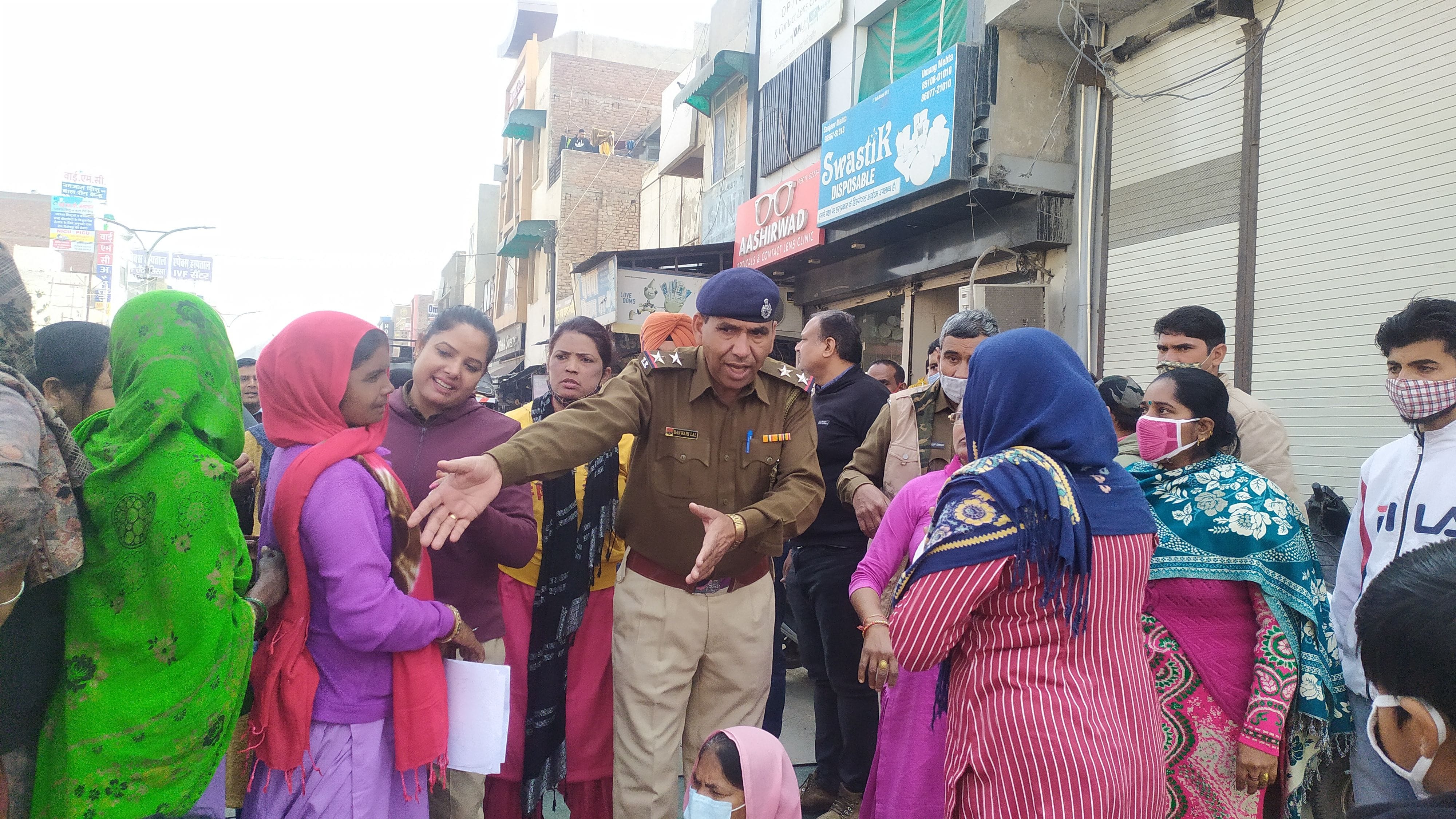 आंगनबाड़ी कार्यकर्ताओं को जाम खोलने के लिए समझाते पुलिसकर्मी।