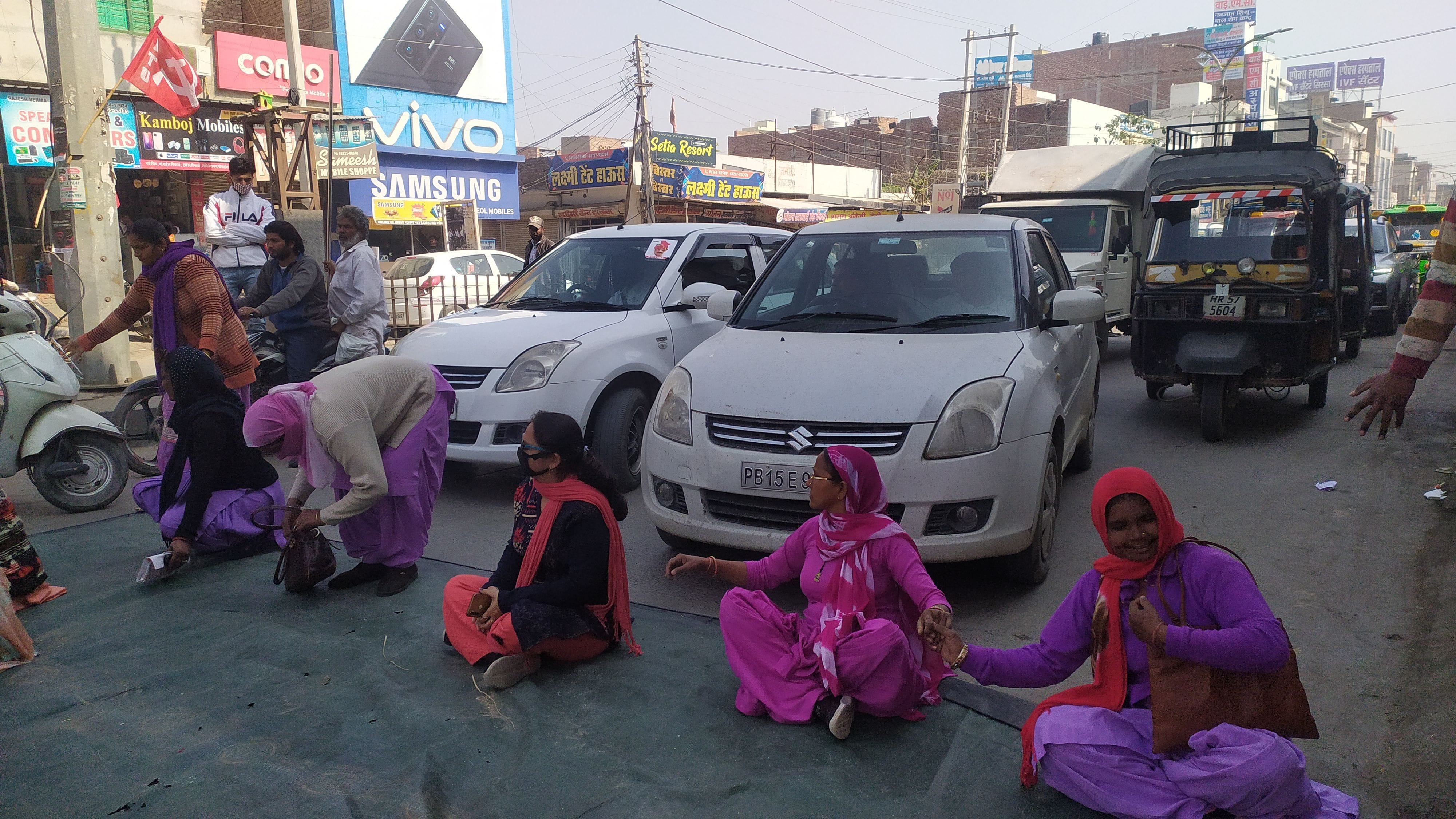 वाहनों के सामने रोड जाम करके बैठी आंगनबाड़ी कार्यकर्ताएं।