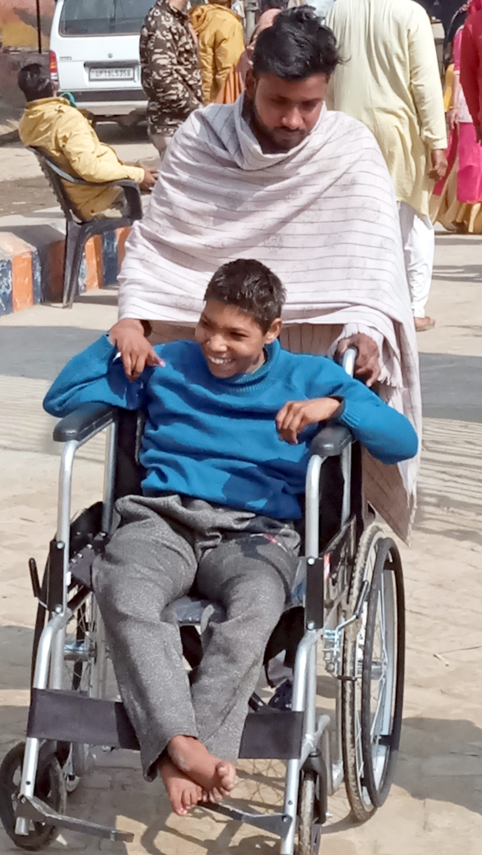 शामली लिसाढ़ में दिव्यांग युवती को व्हील चेयर में बैठा कर वोट डलवाने के लिए ले जाता युवक।