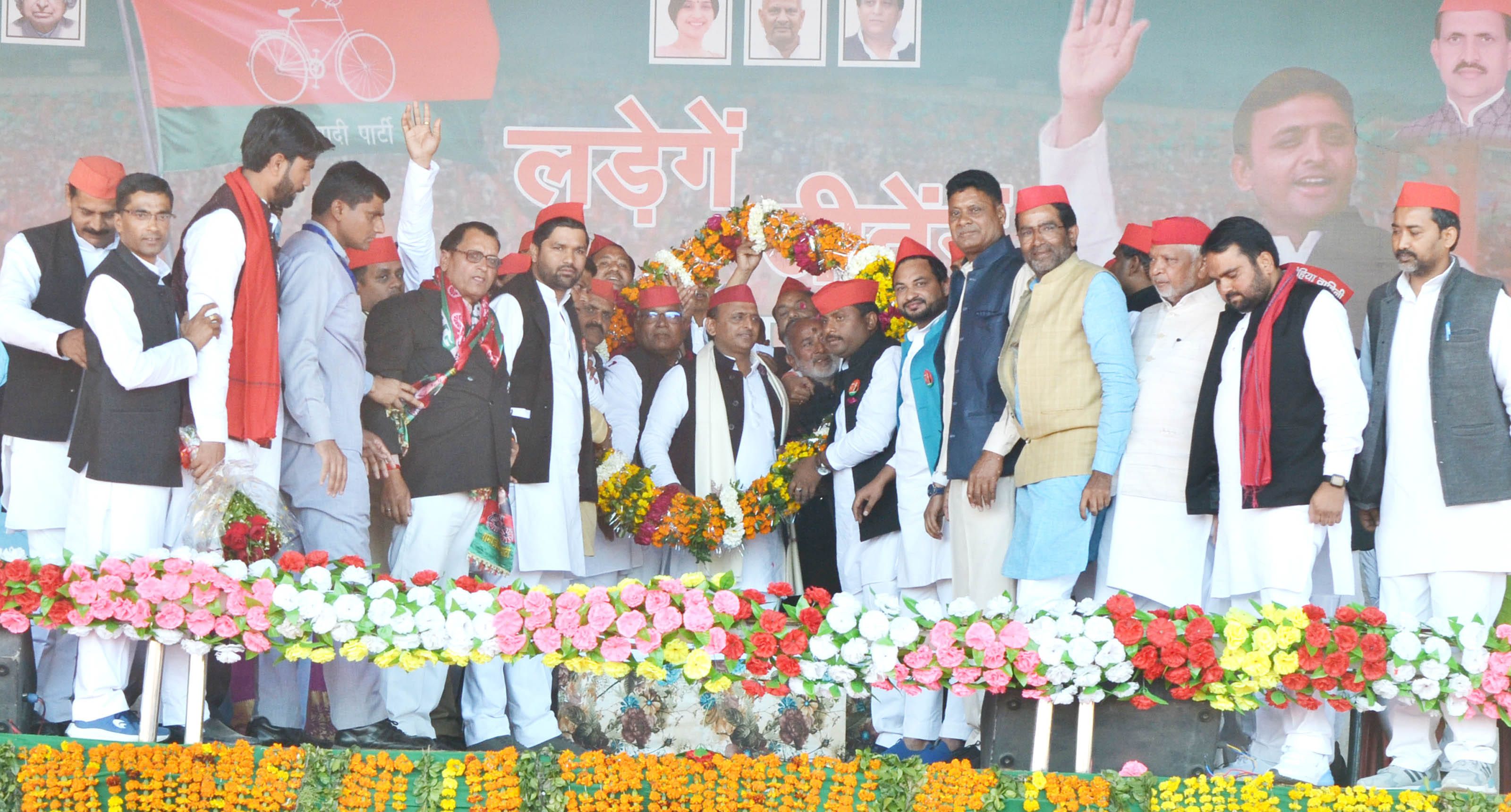 मौदहा कस्बे में सपा राष्ट्रीय अध्यक्ष अखिलेश यादव को माला पहना कर स्वागत करते कार्यकर्ता। संवाद