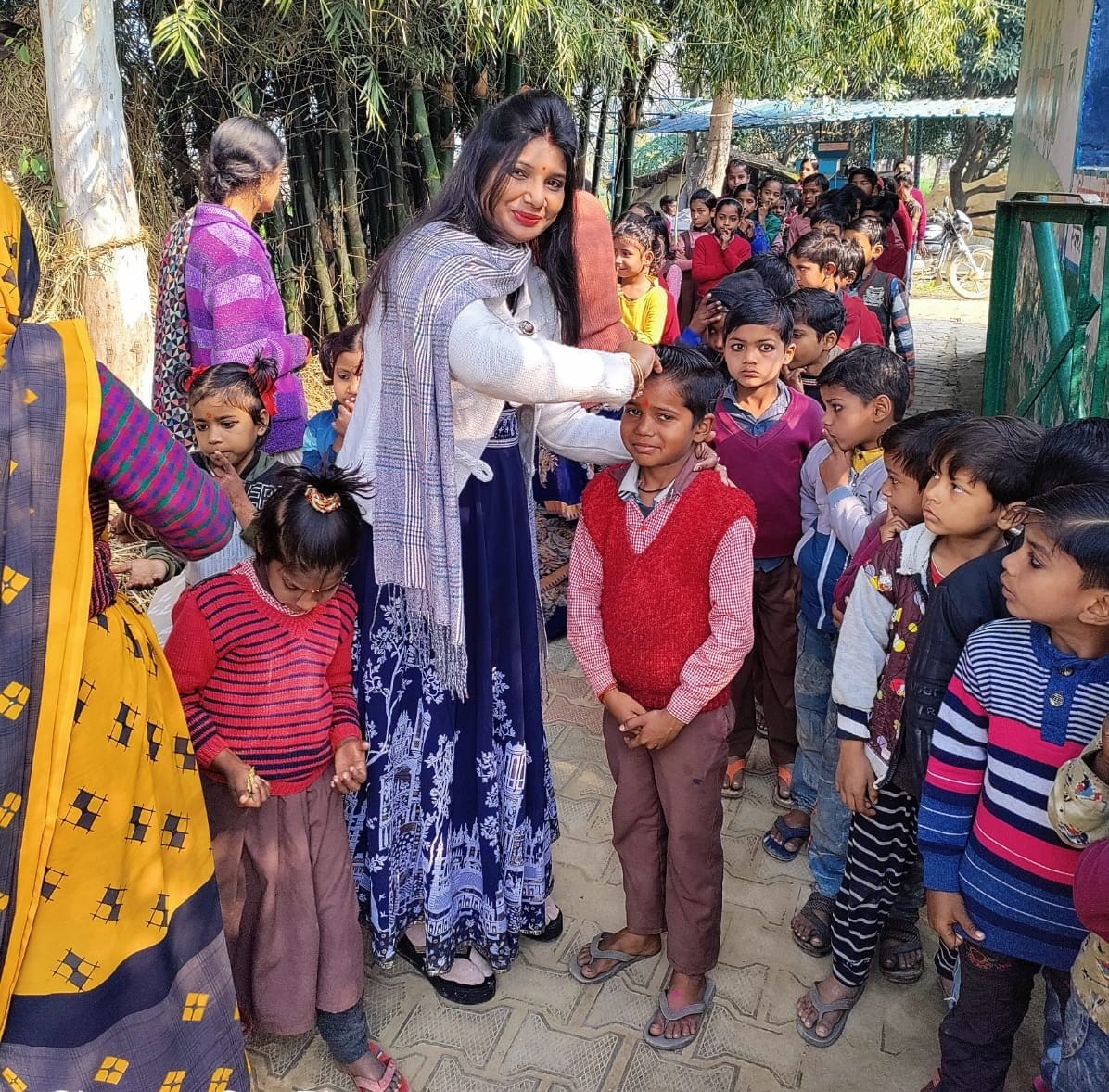 प्राथमिक विद्यालय गनेशपुर में बच्चों को तिलक लगाकर स्वागत करती शिक्षिका