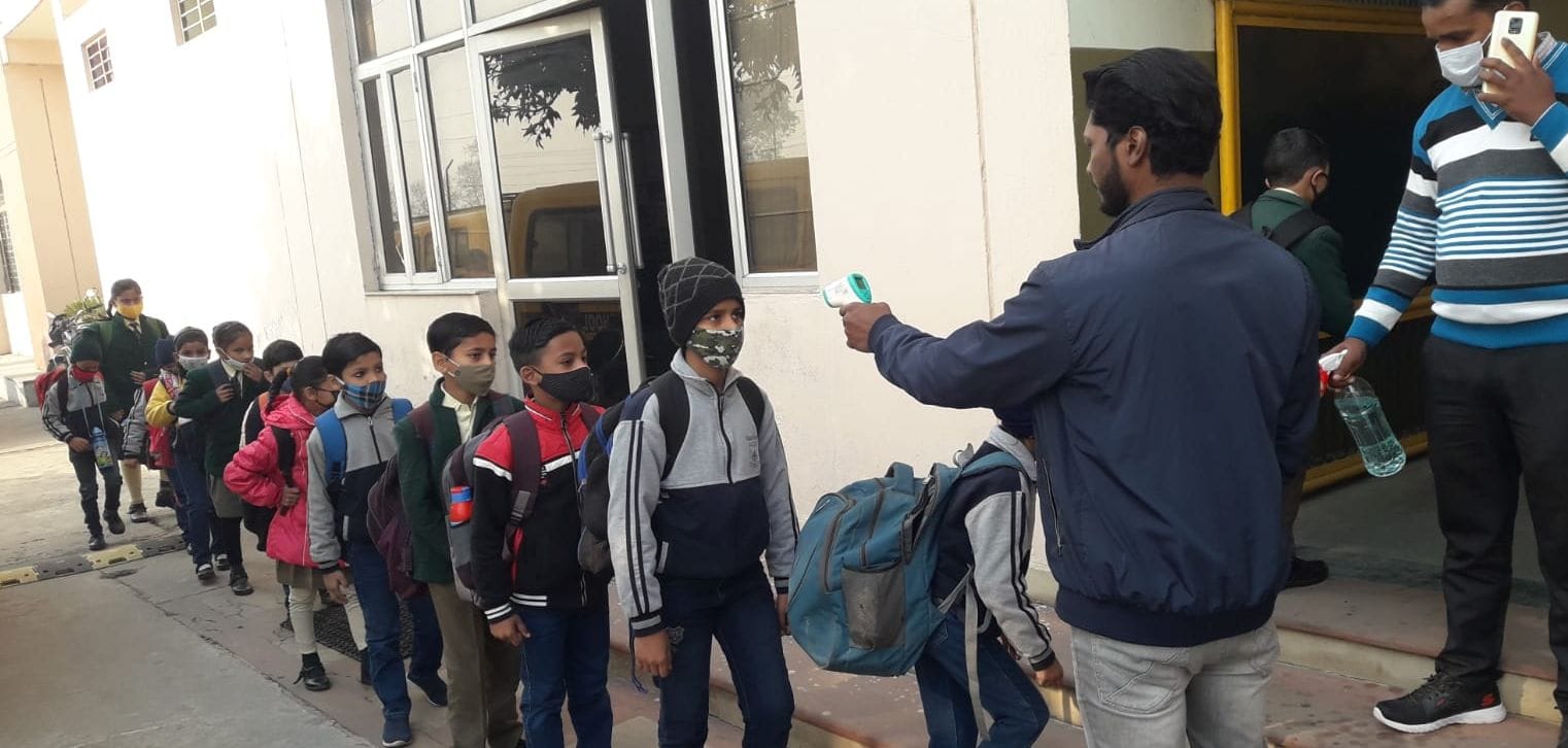 सिल्वर बेल्स स्कूल में पहुंचे बच्चों की थर्मल स्कैनिंग करता कर्मचारी। सिल्वर बेल्स स्कूल में पहुंचे बच्चों की थर्मल स्कैनिंग करता कर्मचारी।