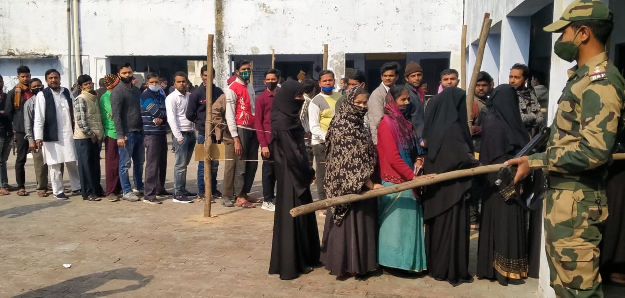 संगीन के पहरे में वोट डालने को लाइन में खड़े मतदाता संगीन के पहरे में वोट डालने को लाइन में खड़े मतदाता