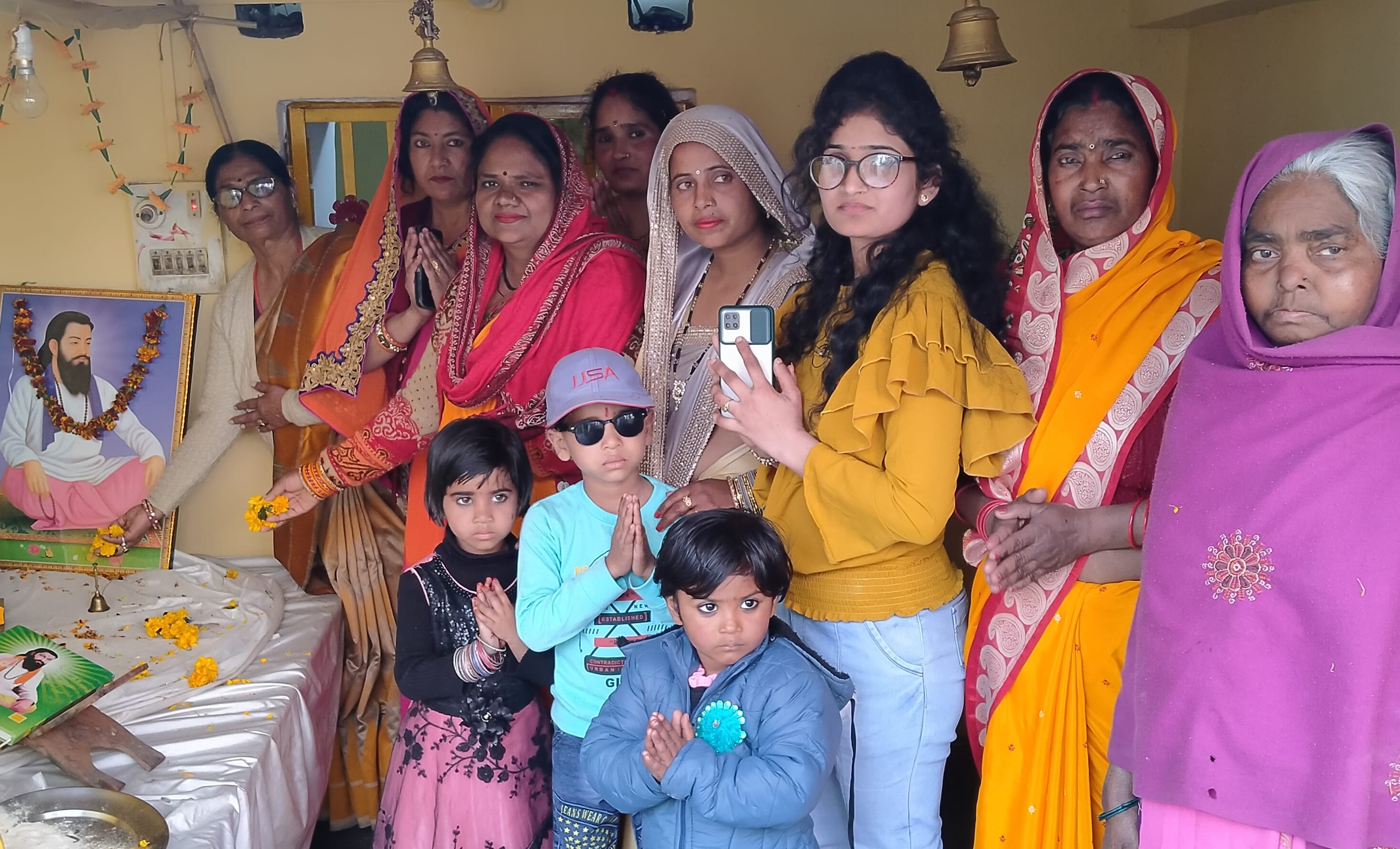 धामपुर में रविदास चित्र के समक्ष श्रद्वा सुमन  अर्पित करती महिलाएं