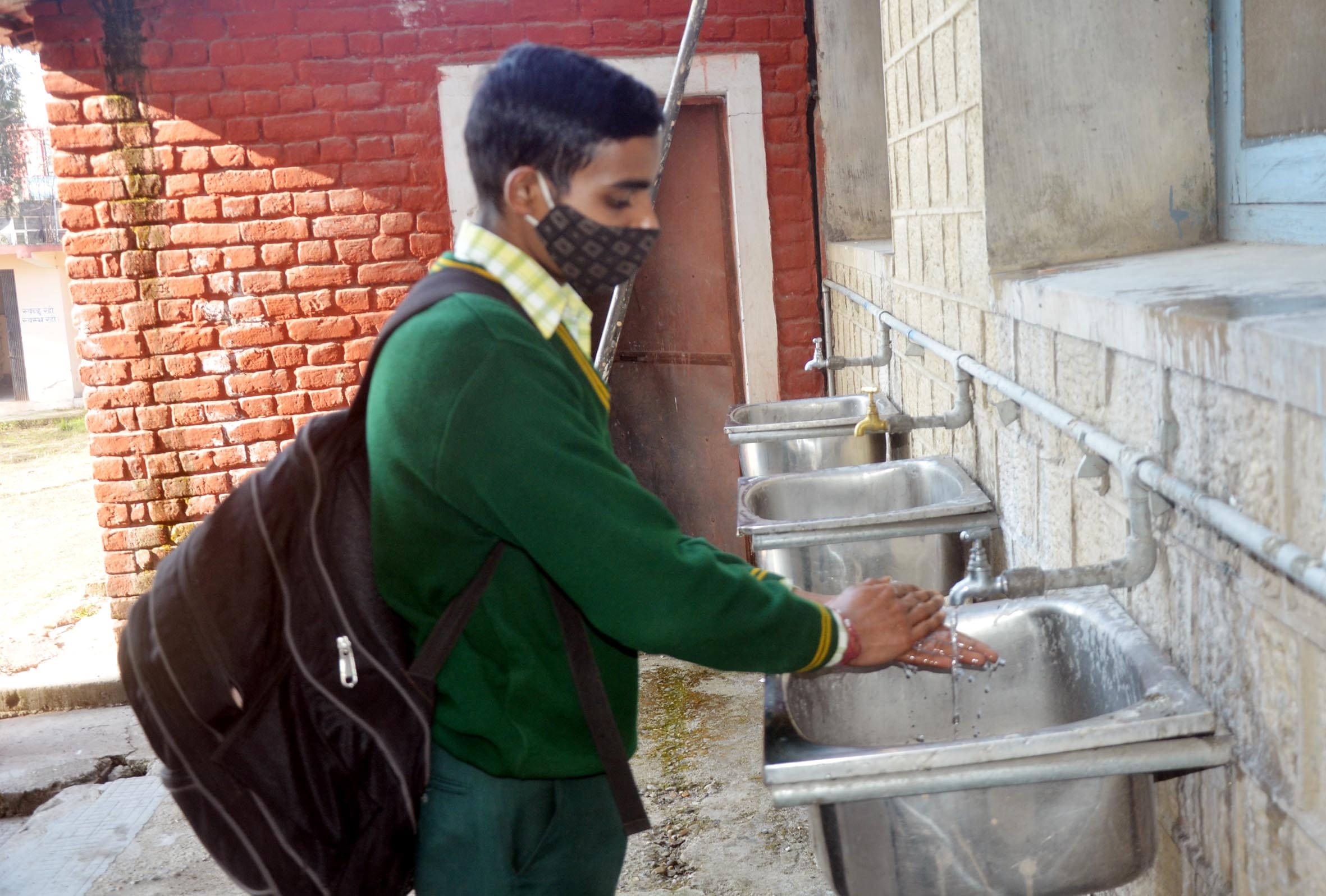 बाल स्कूल हमीरपुर में स्कूल पहुंचने पर हाथ धोता छात्र। बाल स्कूल हमीरपुर में स्कूल पहुंचने पर हाथ धोता छात्र।