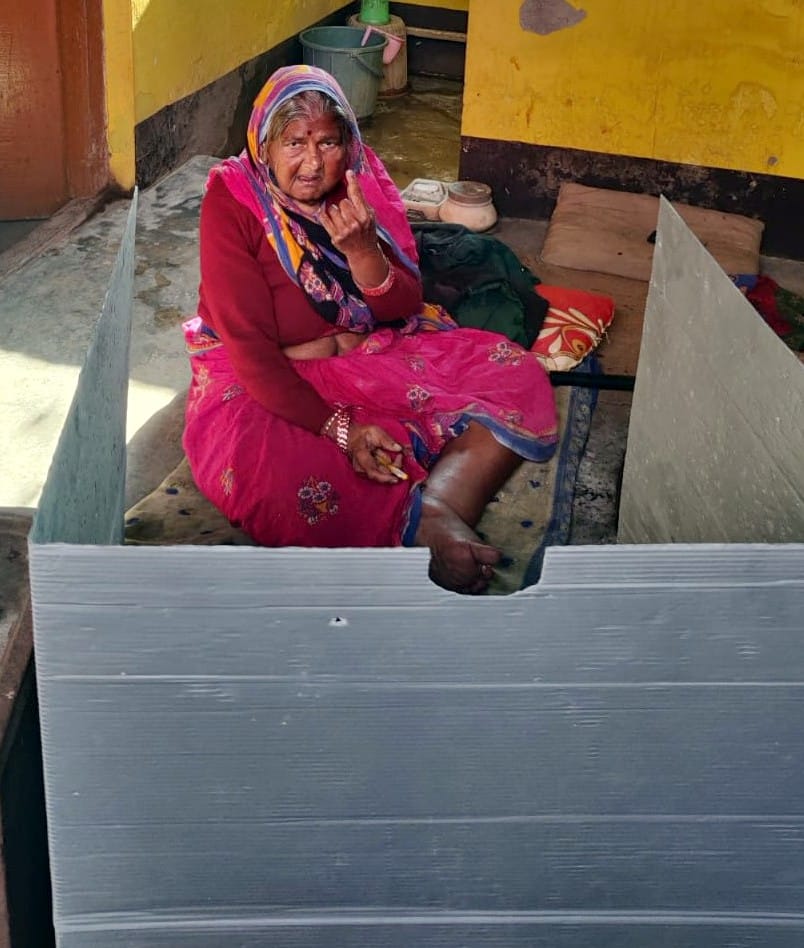 मतदान करने के बाद उंगली पर लगे स्याही दिखाती वृद्धा