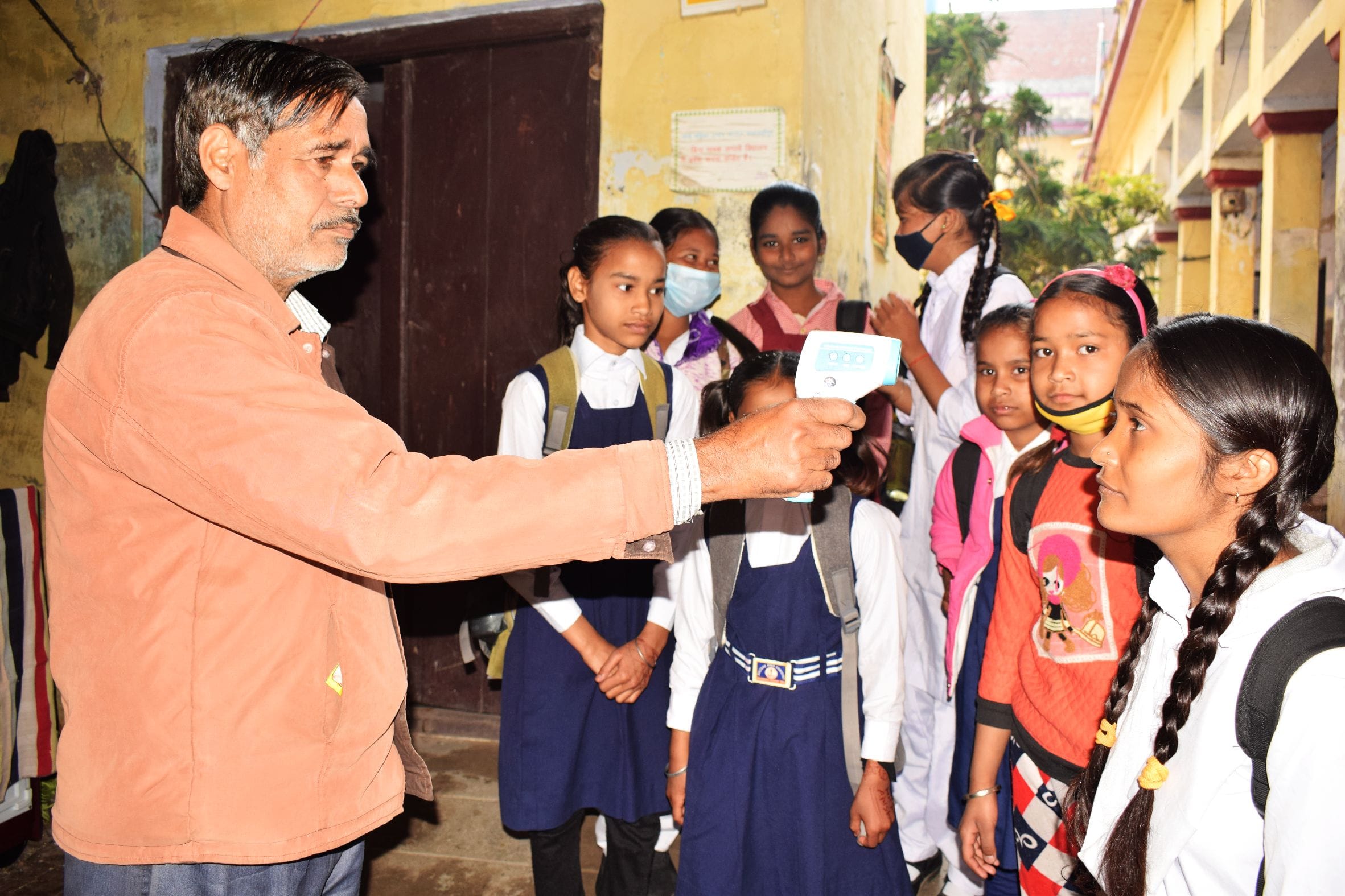 शाहजहांपुर में स्कूल आने पर छात्राओं की थर्मल स्क्रीनिंग की करता कर्मचारी । संवाद शाहजहांपुर में स्कूल आने पर छात्राओं की थर्मल स्क्रीनिंग की करता कर्मचारी । संवाद