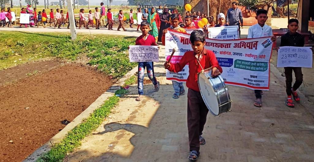 मैलानी के नारंग में रैली निकालते स्कूली बच्चे