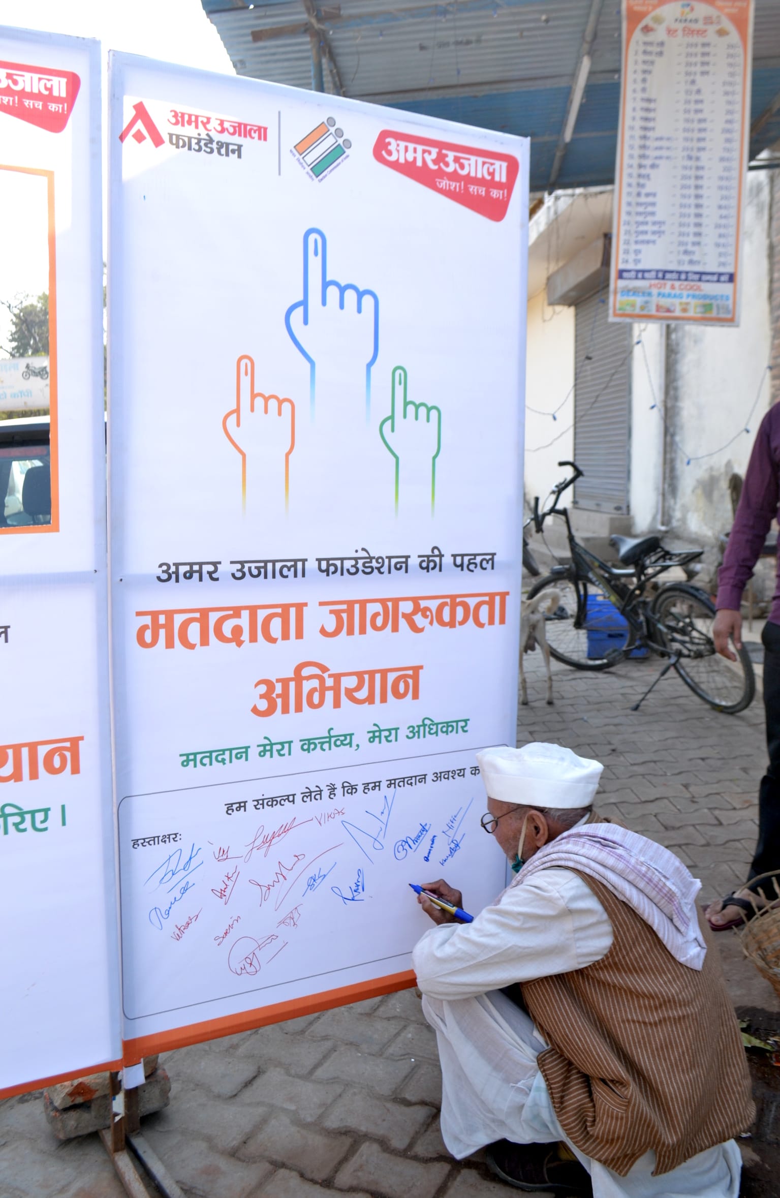 अमर उजाला के मतदाता जागरूकता अभियान में हस्ताक्षर करता बुजुर्ग अमर उजाला के मतदाता जागरूकता अभियान में हस्ताक्षर करता बुजुर्ग