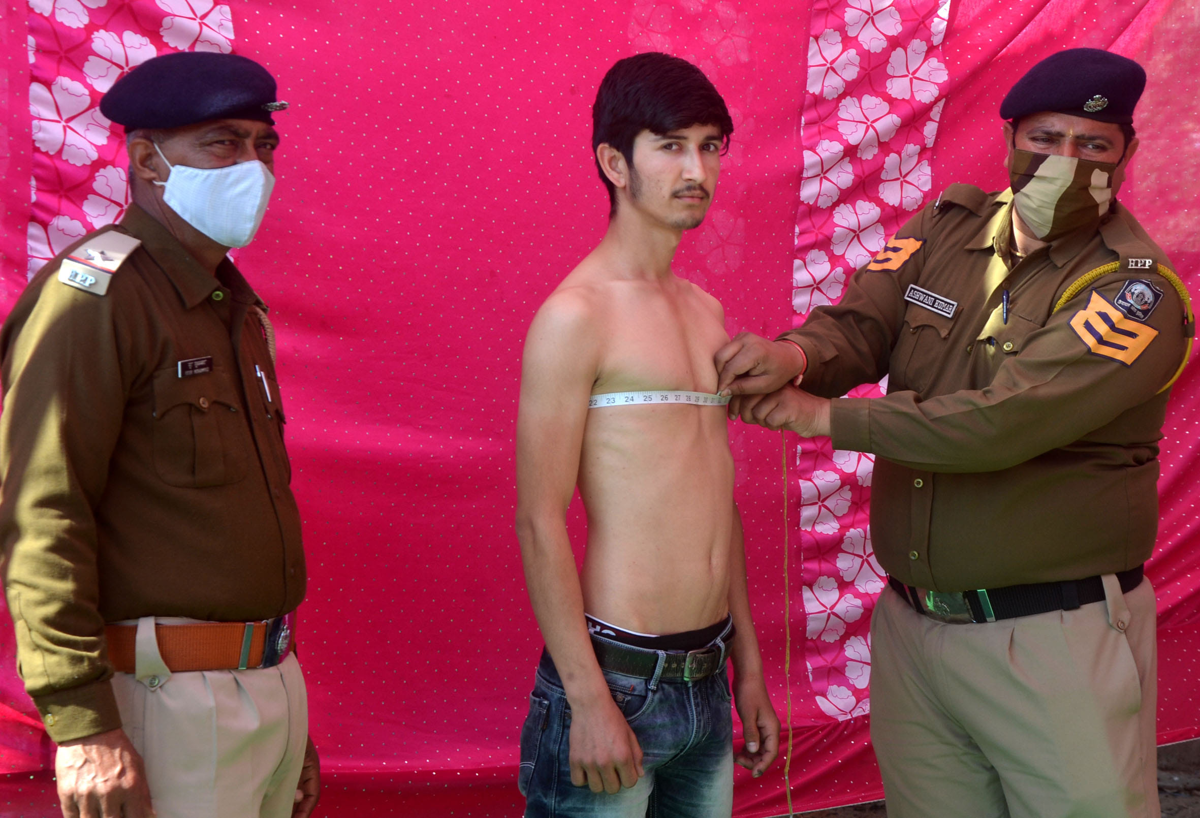 ुलिस भर्ती के दौरान अभ्यर्थी की छाती मापते पुलिस कर्मचारी।