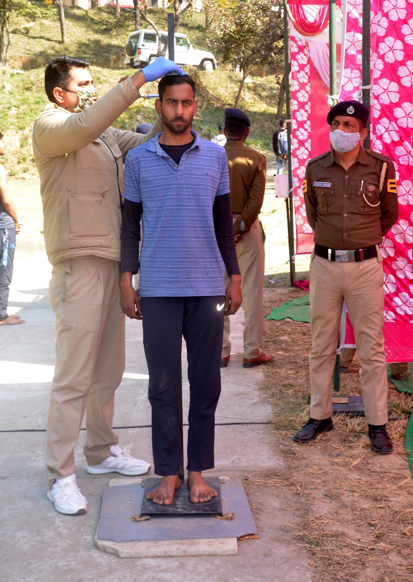पुलिस भर्ती के दौरान अभ्यर्थी की लंबाई मापते पुलिस कर्मचारी।