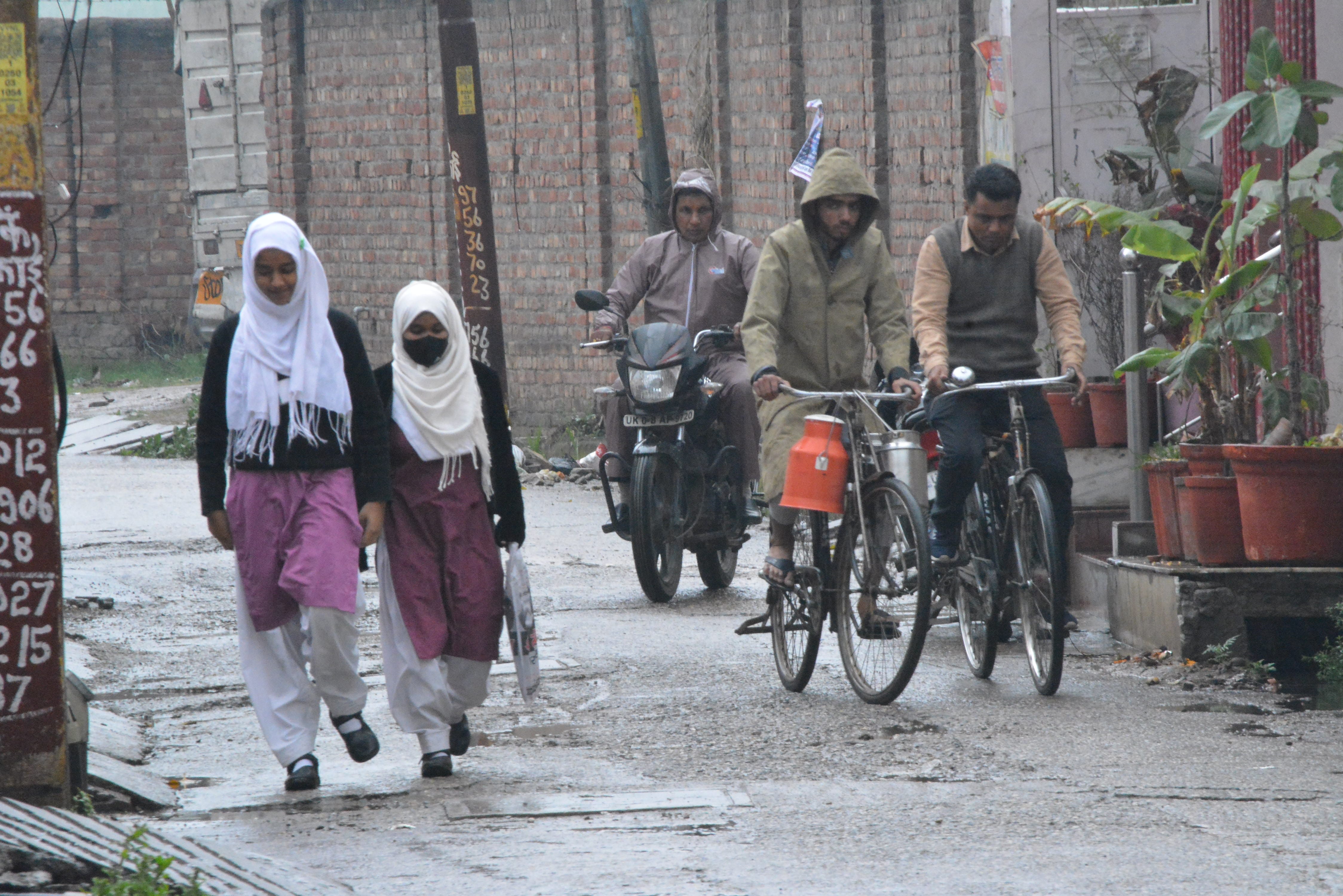 मुजफ्फरनगर में सुबह बारिश में गंतव्य को  छात्राएं व राहगीर।