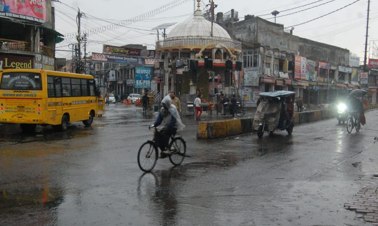 मुजफ्फरनगर में सुबह बारिश में शिव चौक से गुजरते  साईकिल सवार।