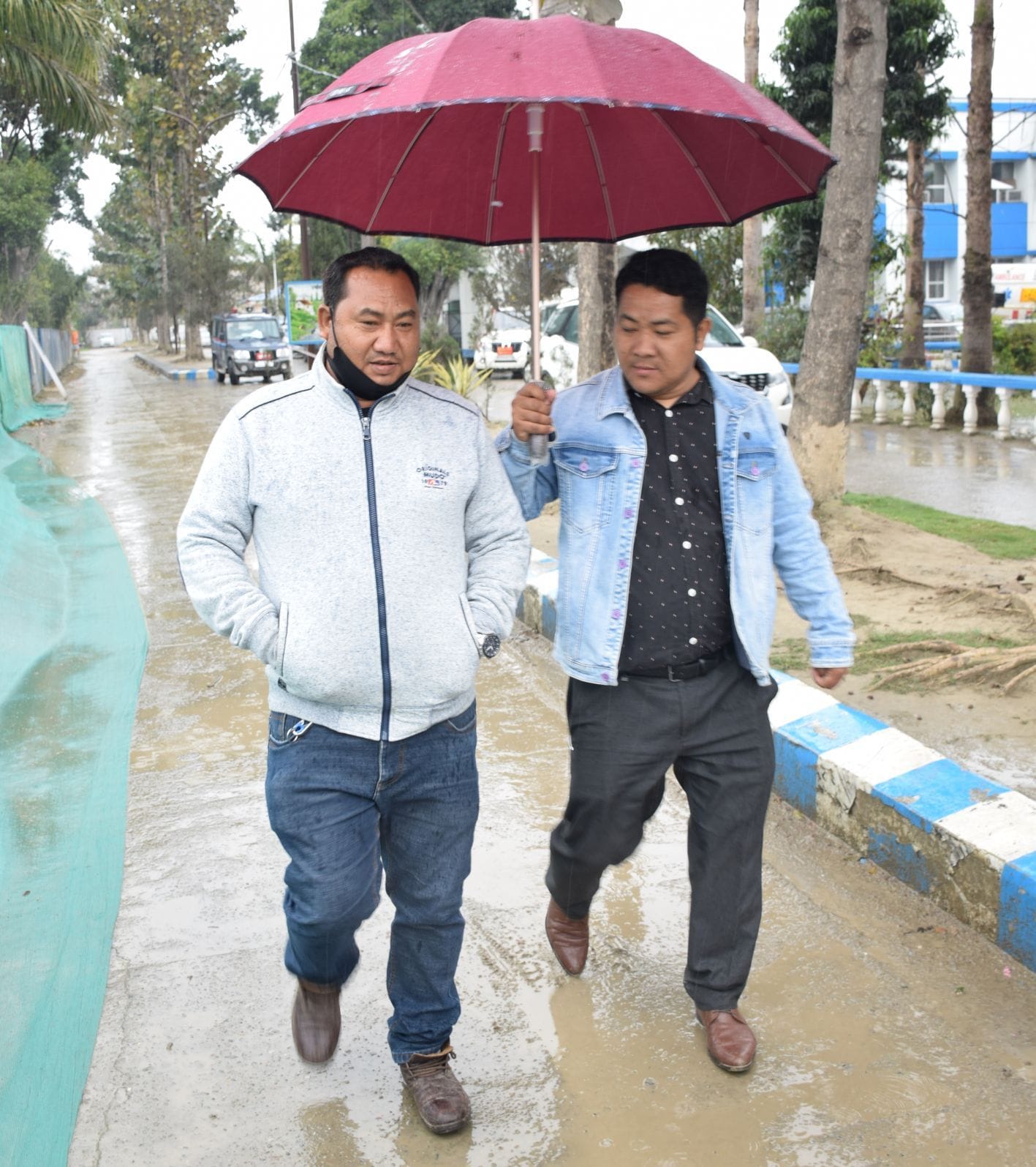 रुद्रपुर में बारिश से बचने के लिए छाता लगाकर गुजरते लोग। रुद्रपुर में बारिश से बचने के लिए छाता लगाकर गुजरते लोग।