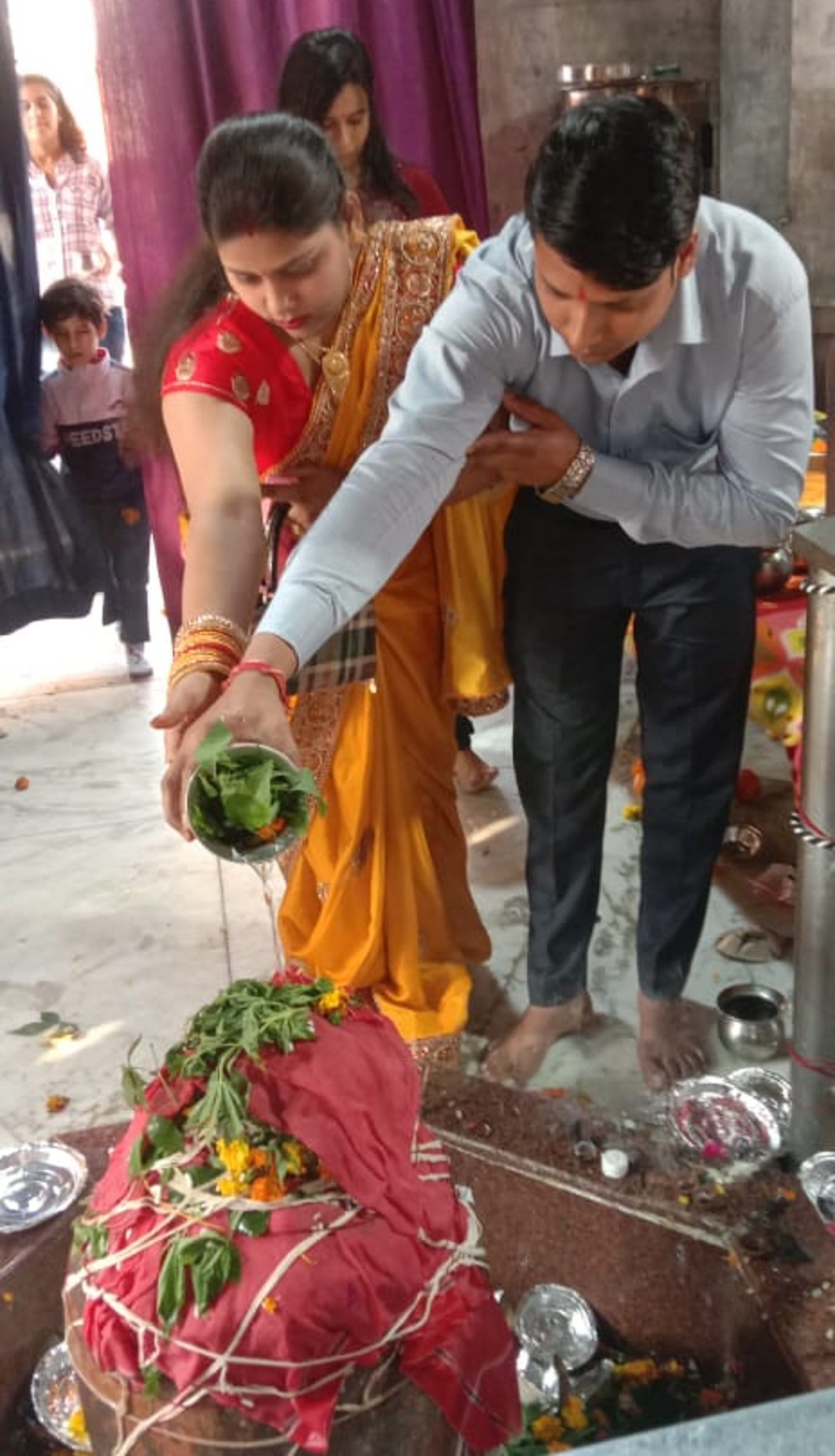 बालैनी के पुरा महादेव मंदिर में जलाभिषेक करते हुए