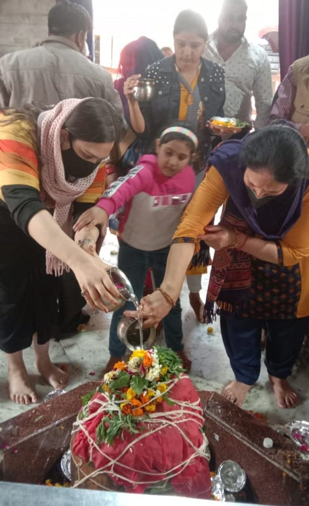 बालैनी के पुरा महादेव मंदिर में जलाभिषेक करते शिवभक्त