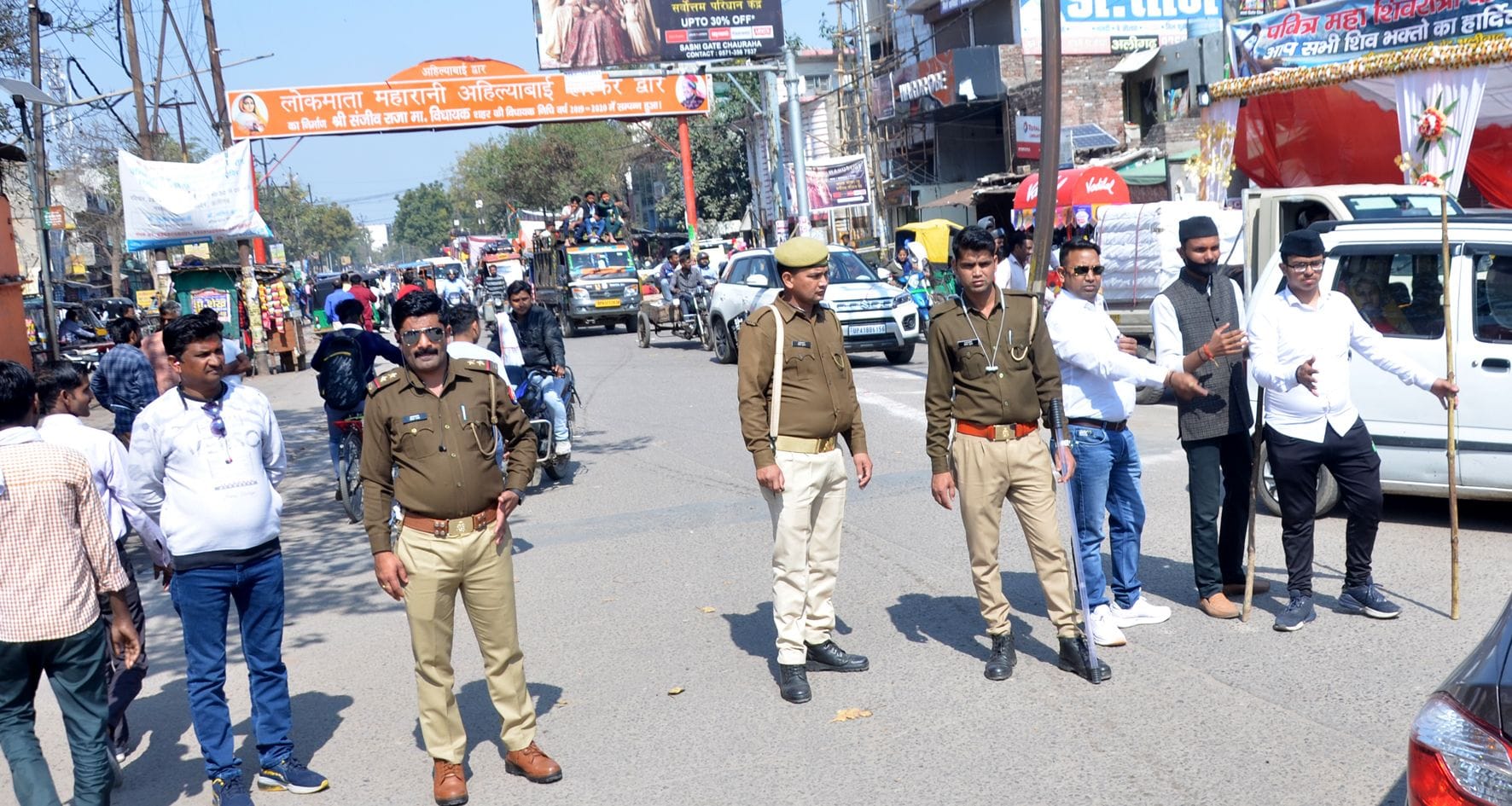सासनी गेट चौराहे पर कांवड़ियों की व्यवस्था में लगे पुलिस कर्मी व आरएसएस के कार्यकर्ता।