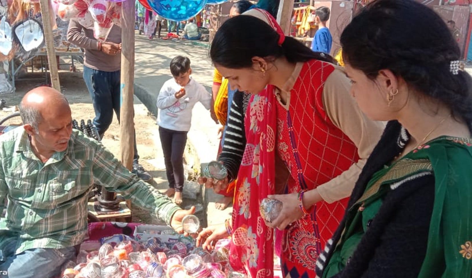 बालैनी के पुरा महादेव मंदिर में जलाभिषेक के बाद मेले में खरीदारी करती महिलाएं बालैनी के पुरा महादेव मंदिर में जलाभिषेक के बाद मेले में खरीदारी करती महिलाएं