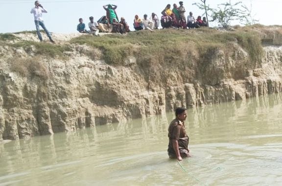 शव निकालने के लिए तालाब में जाते एसआई प्रवीण यादव। संवाद