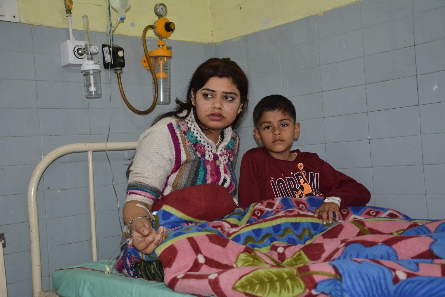जिला चिकित्सालय में भर्ती फूड प्वाइजनिंग के मरीज खुशबू अपने बेटे के साथ।