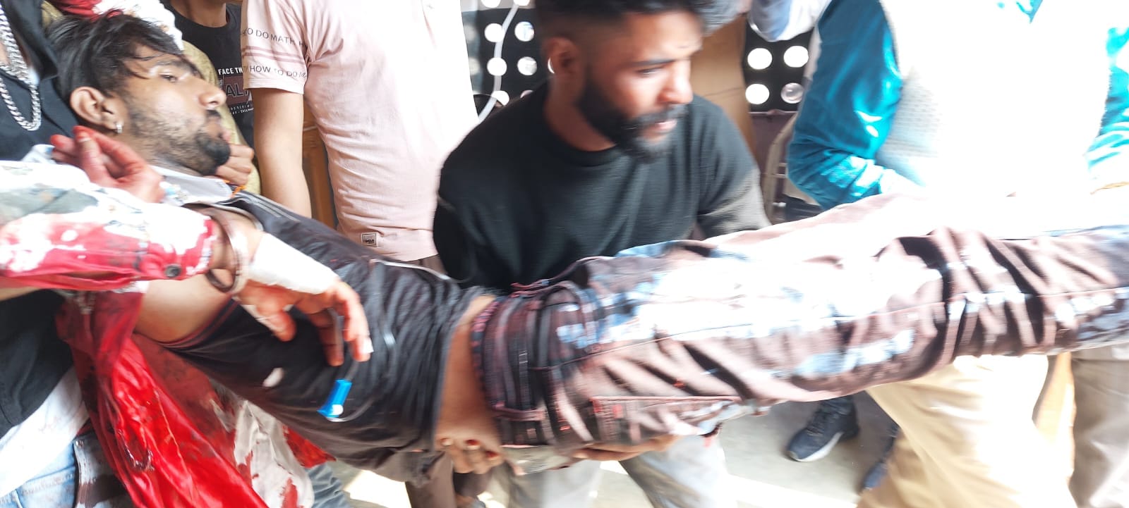 हमले में घायल को अस्पताल ले जाते लोग