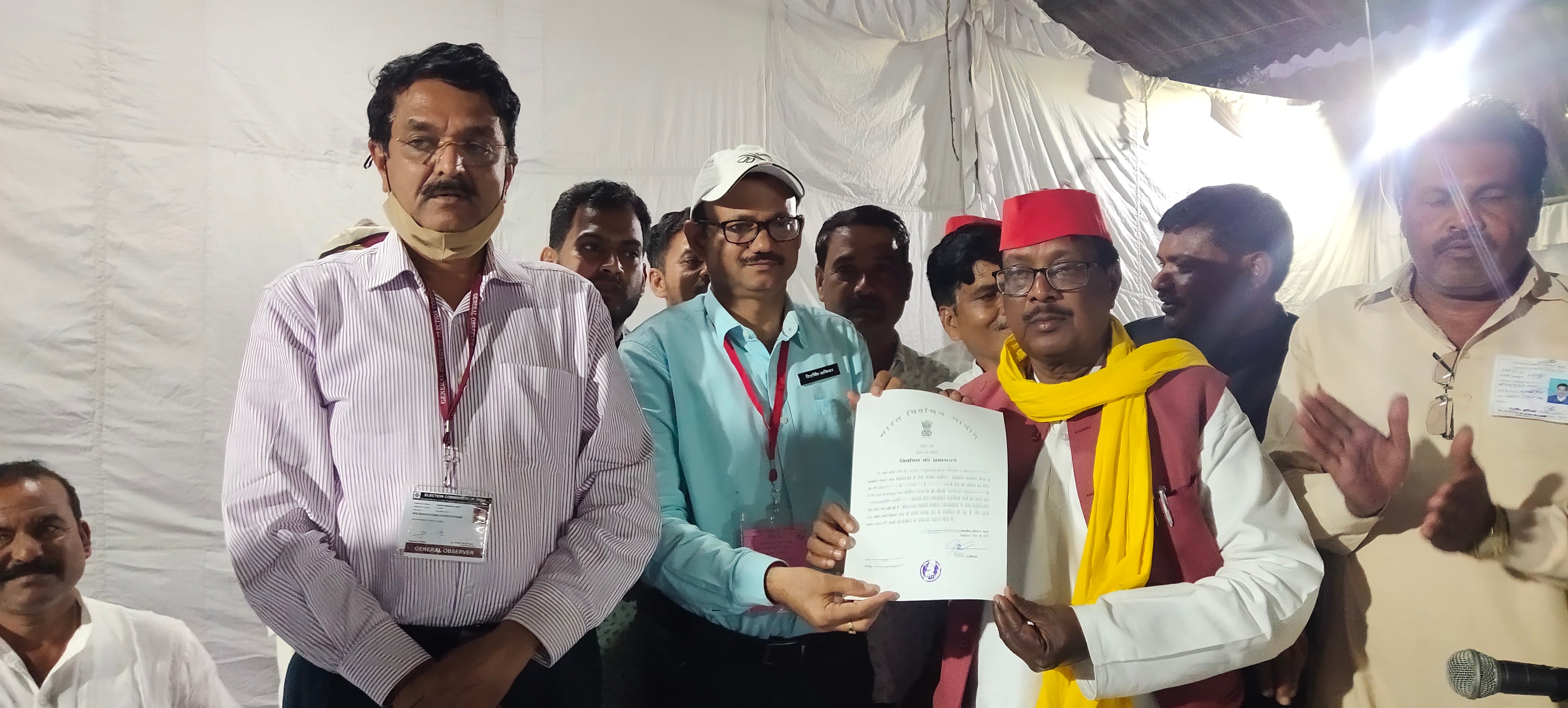 फीत के बाद प्रमाण पत्र प्राप्त करते  मुहम्मदाबाद गोहना विधानसभा से सपा प् त्याशी राजेन्द्र कुमा?