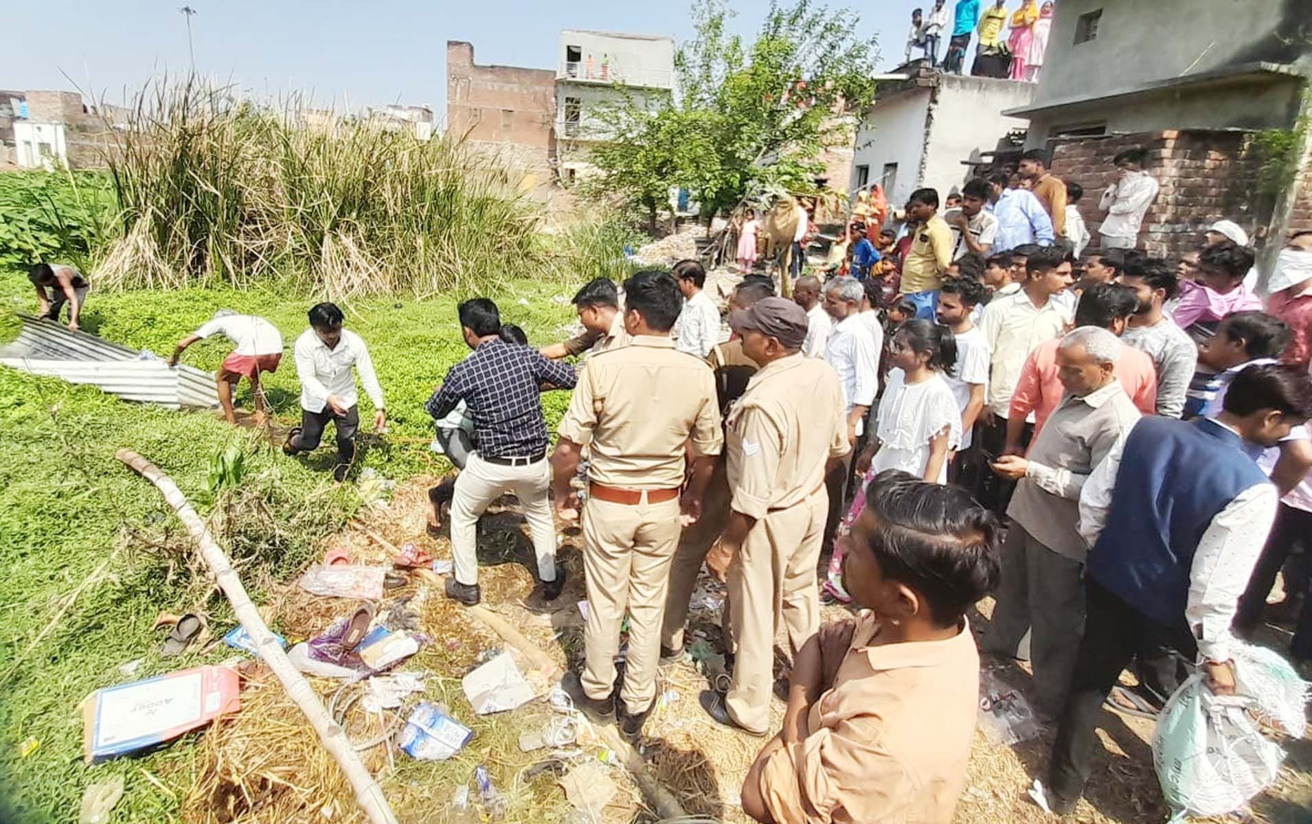 खुटार में तालाब में गिरी वृद्घा को बचाने का प्रयास करते लोग और मौके पर लगी भीड़