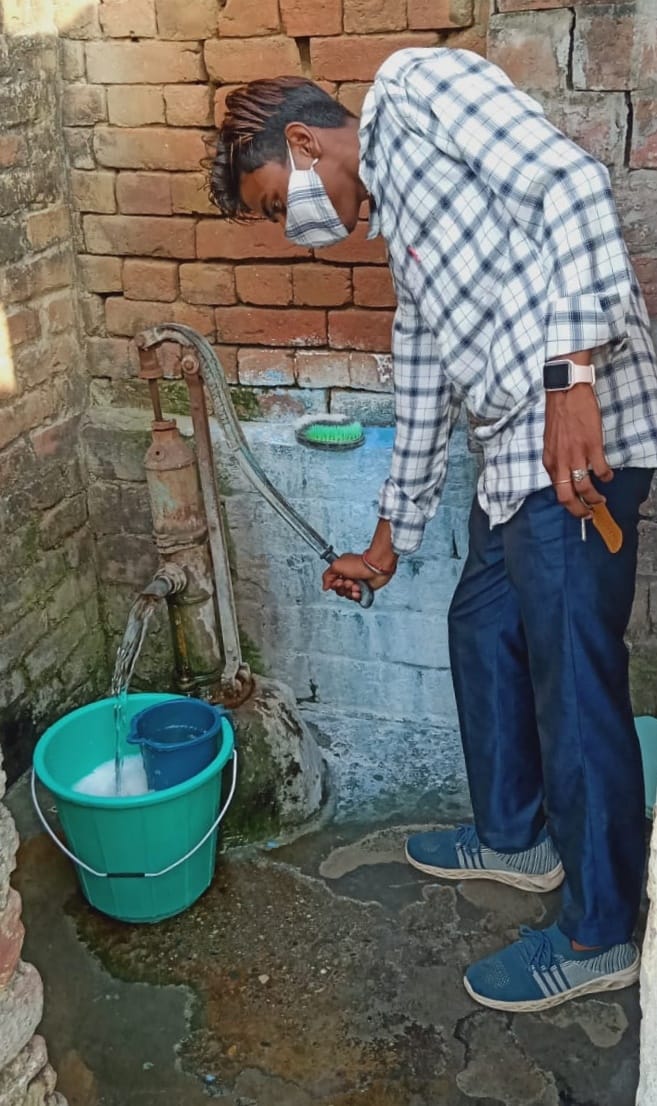 वार्ड नंबर आठ में हैंडपंप से पानी लेता युवक।