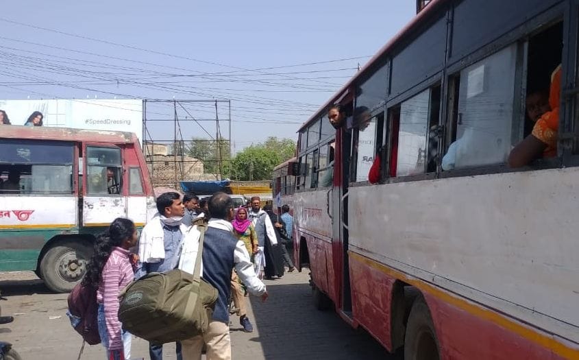 शाहजहांपुर में बस पर सवार होने के लिए दौड़ते यात्री