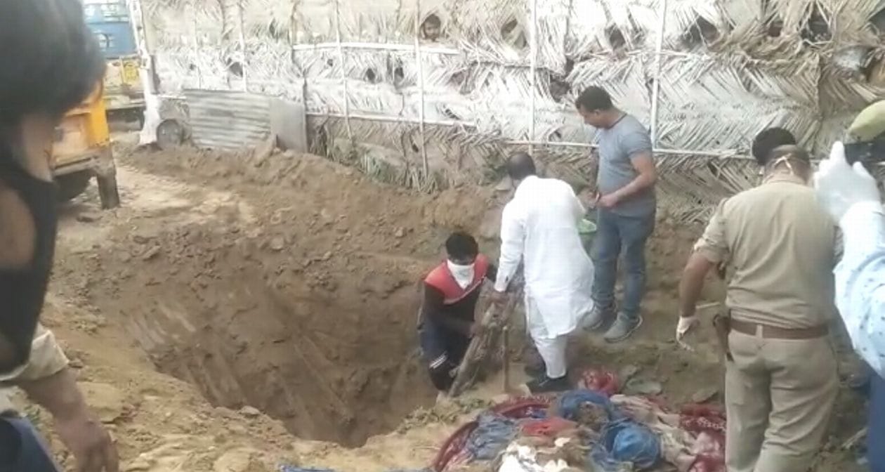 सोमवार को बुलंदशहर रोड स्थित कुराना टोल के पास गड्ढा खोदकर युवक का शव निकालते लोग । संवाद सोमवार को बुलंदशहर रोड स्थित कुराना टोल के पास गड्ढा खोदकर युवक का शव निकालते लोग । संवाद
