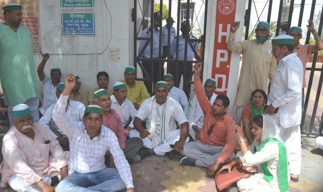 मंगलवार को एचपीडीए कार्यालय के गेट पर ताला लगाकर धरना देते किसान  । संवाद