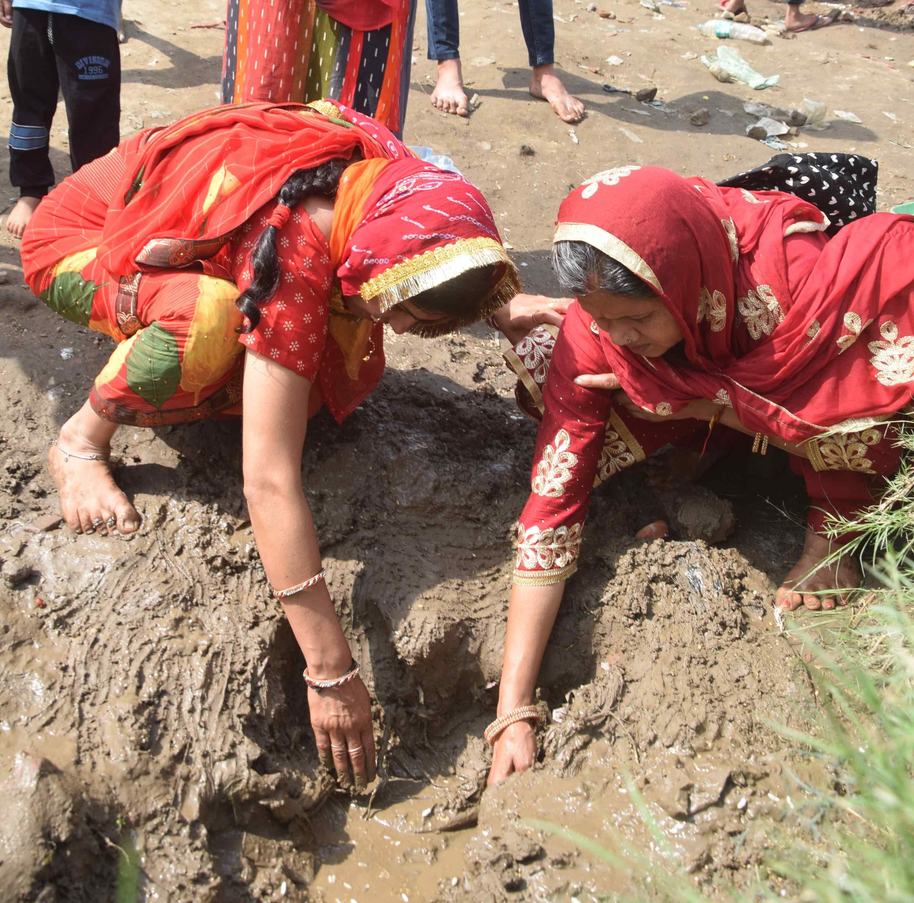 माता दरवाजा स्थित शीतला माता मंदिर पूजन के बाद तालाब से मिट्टी निकालतीं महिलाएं। अमर उजाला माता दरवाजा स्थित शीतला माता मंदिर पूजन के बाद तालाब से मिट्टी निकालतीं महिलाएं। अमर उजाला