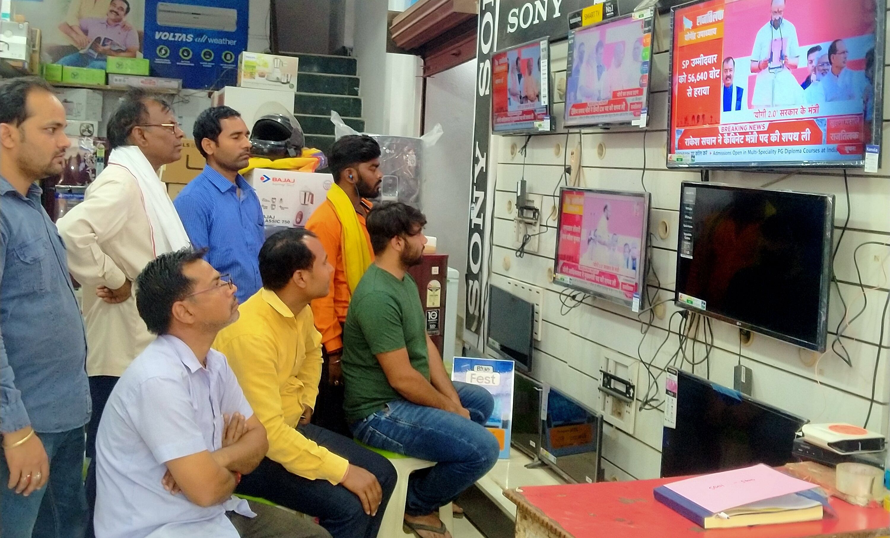 Les gens regardent la prestation de serment du ministre en chef Yogi Adityanath à la télévision à Robertsganj.
