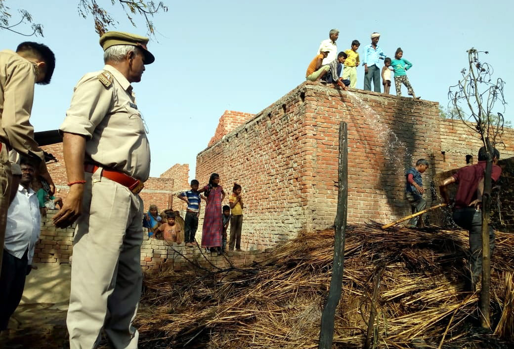 फोटो 26सीएचबीपी63: छत से पानी डालकर आग बुझाने का प्रयास करते युवक। संवाद