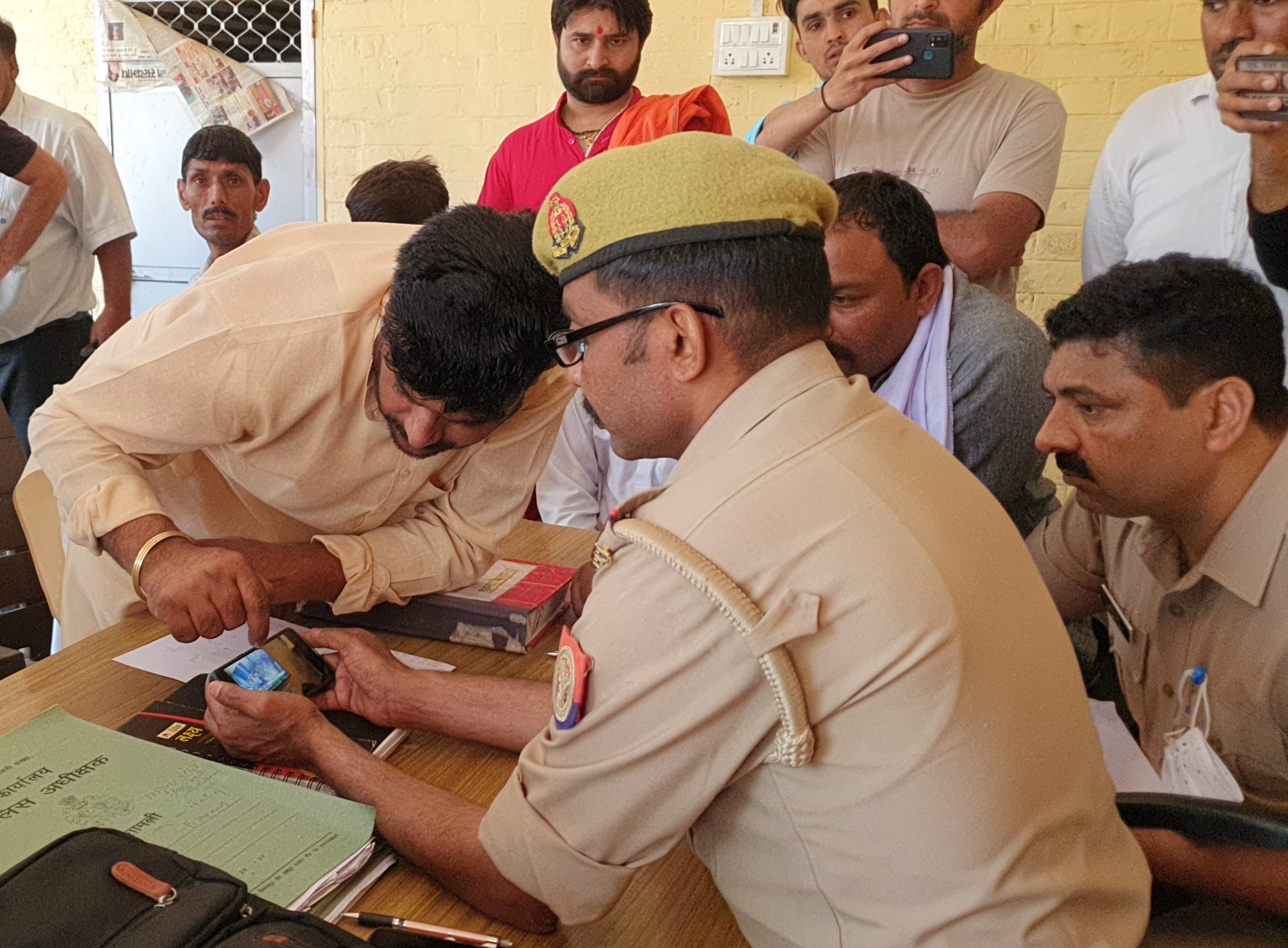 शामली : कैराना में पुलिस को मोबाइल में स्कूल की सीसीटीवी फुटेज दिखाते ग्रामीण।