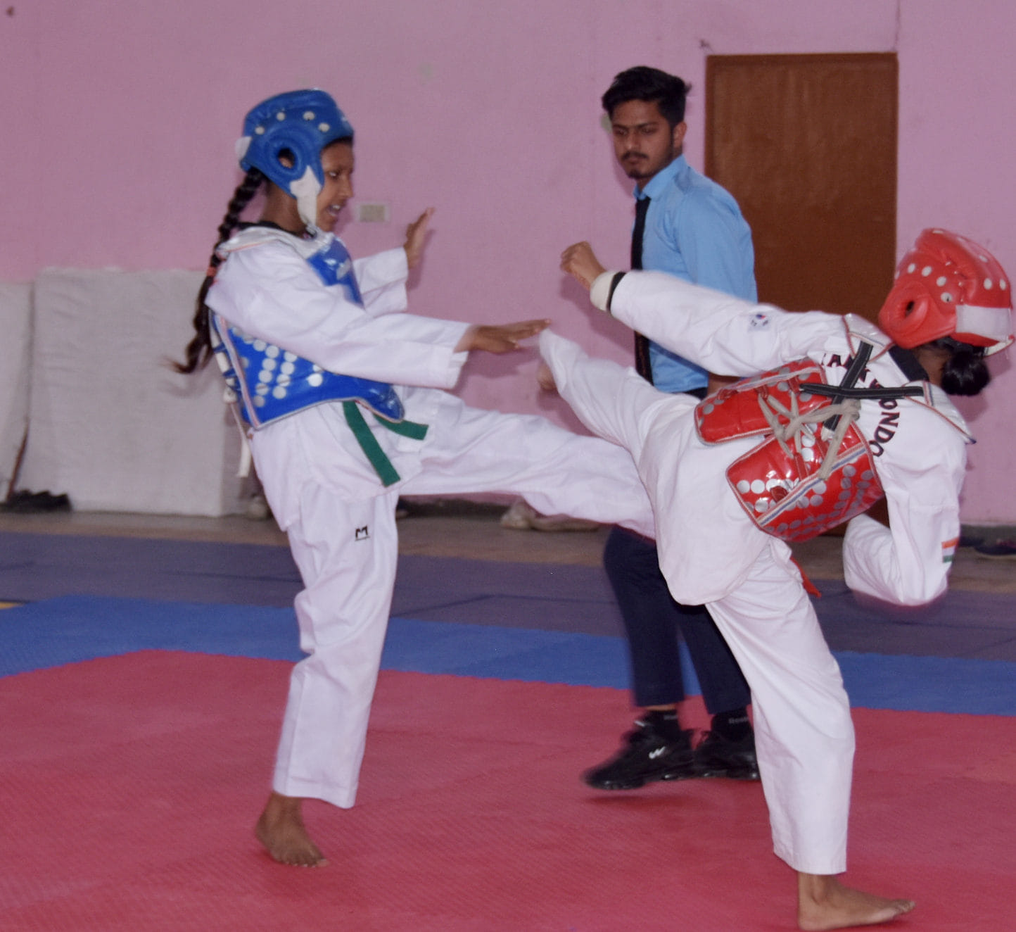 स्टेडियम में आयोजित जिला स्तरीय ताइक्वांडो प्रतियोगिता में खेलते खिलाड़ी