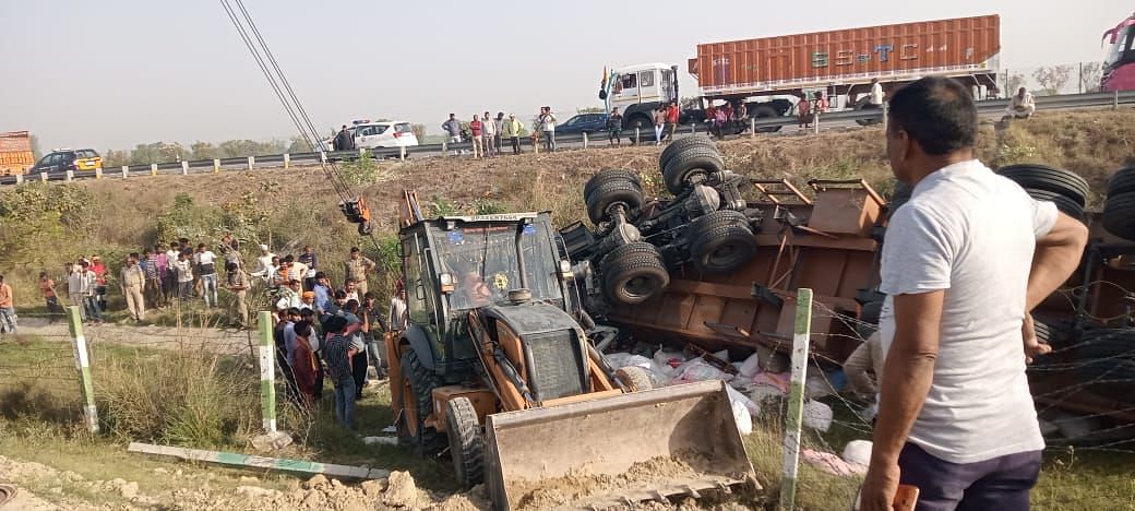 ट्रक में फंसे चालक-क्लीनर को निकालने पहुंची जेसीबी व मौजूद भीड़। संवाद