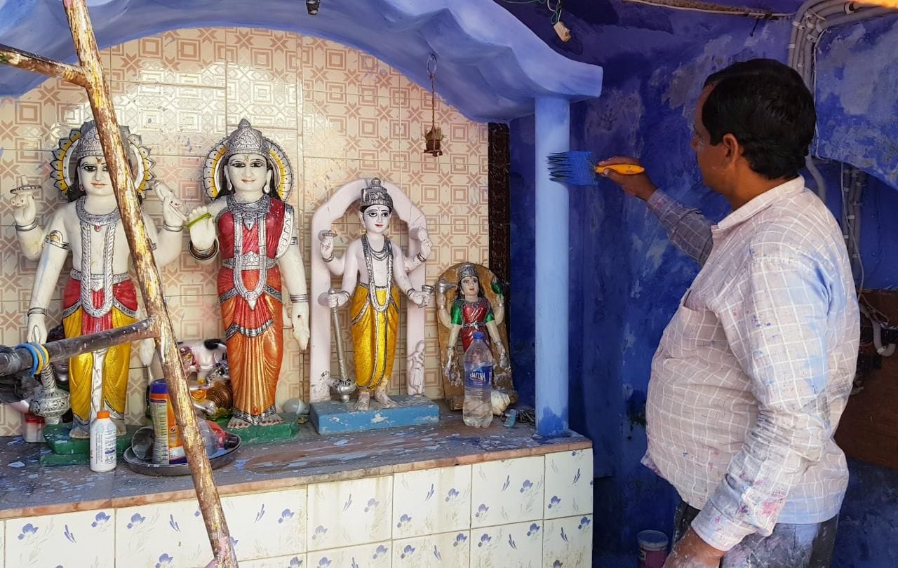 माता पथवारी मंदिर में रंगाई-पुताई करता श्रमिक। संवाद