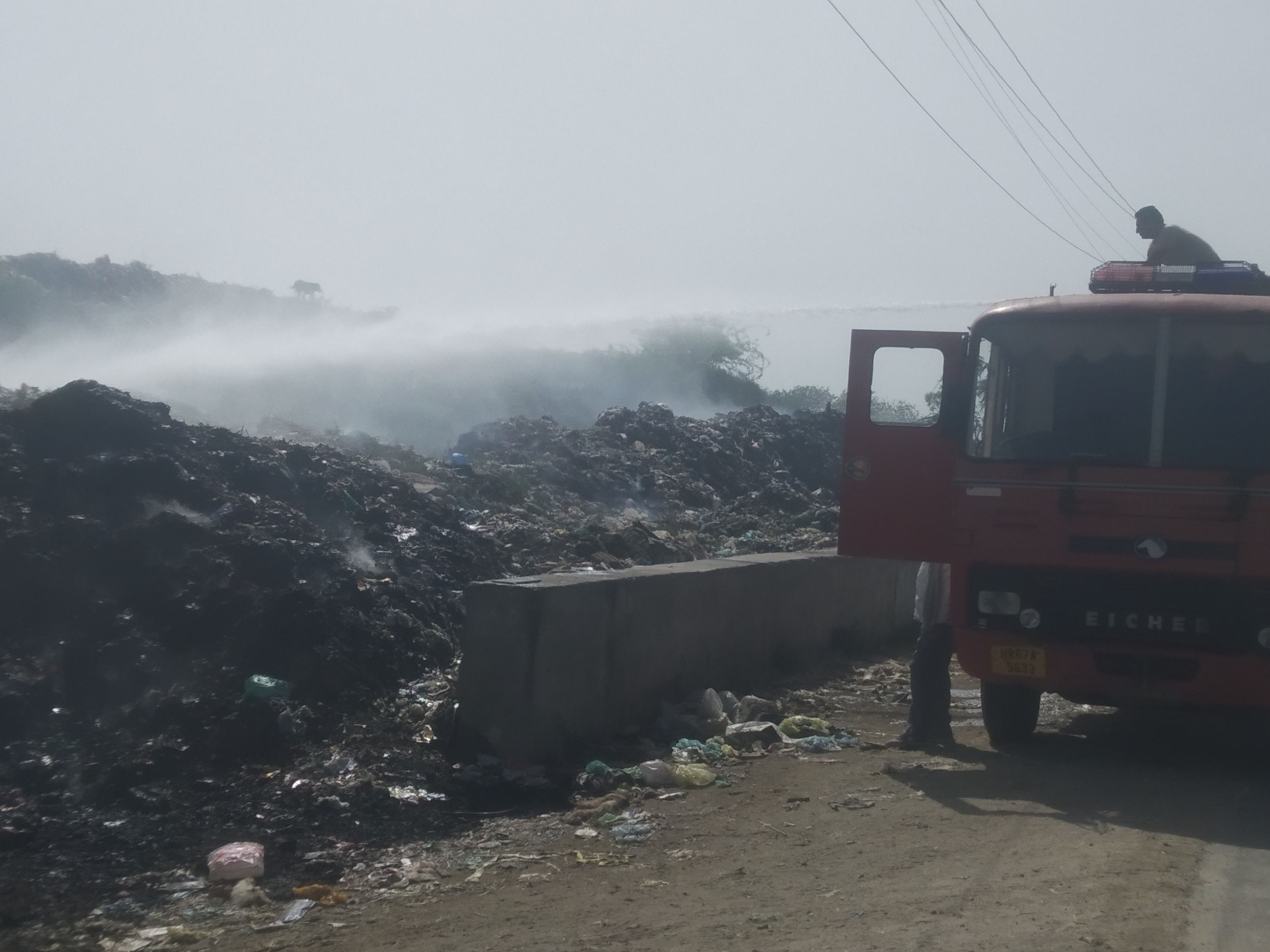 समालखा। गढी छाजू रोड पर कूड़े में अगी आग को  बुझाते हुए फायर कर्मी।