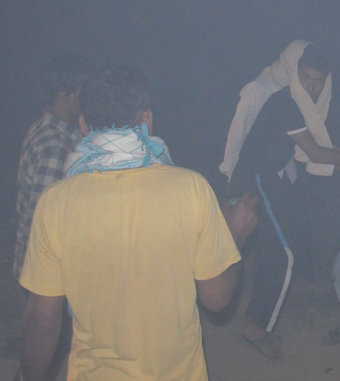 बागपत में कूड़े के ढेर में आग लगने से धुआं होने पर सुरक्षित स्थान की ओर जाते लोग।