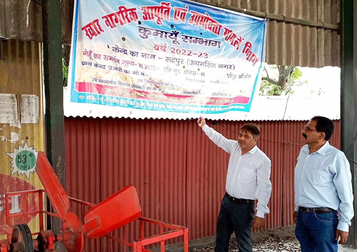 रुद्रपुर गल्ला मंडी स्थित क्रय केंद्र पर बैनर लगाते एसएमओ हेमंत जोशी।