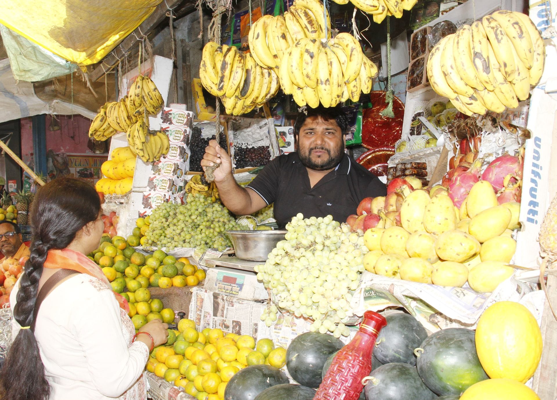 बाजार में फल की दुकान से खरीदती महिला। संवाद बाजार में फल की दुकान से खरीदती महिला। संवाद