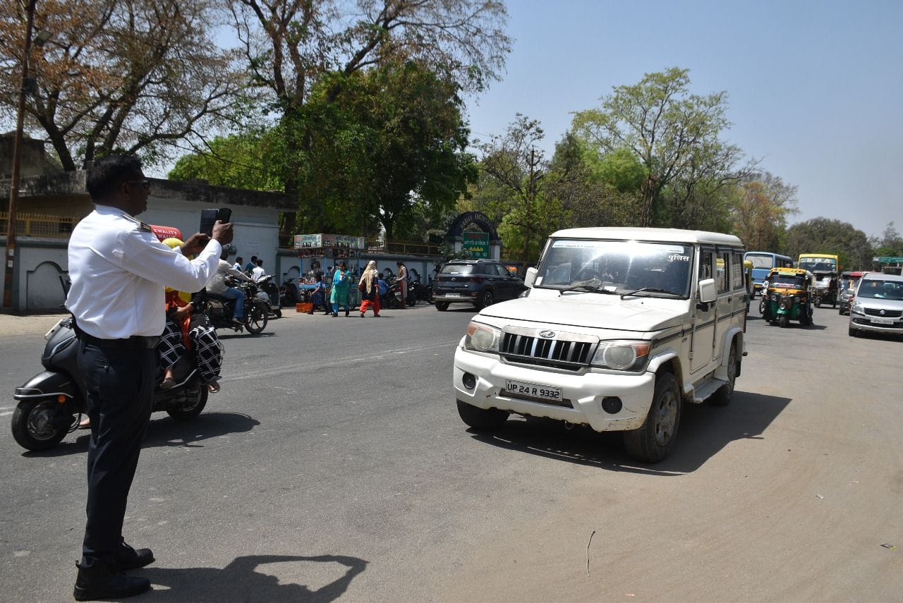 बीच सड़क पर खड़ी कार का चालान करते ट्रेफिक पुलिस कर्मी बीच सड़क पर खड़ी कार का चालान करते ट्रेफिक पुलिस कर्मी