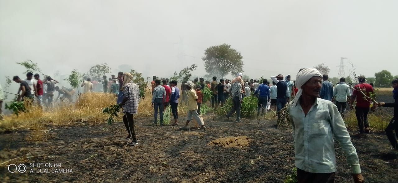 चंद्रपुरा गांव में गेहूं की फसल को बुझाते ग्रामीण चंद्रपुरा गांव में गेहूं की फसल को बुझाते ग्रामीण