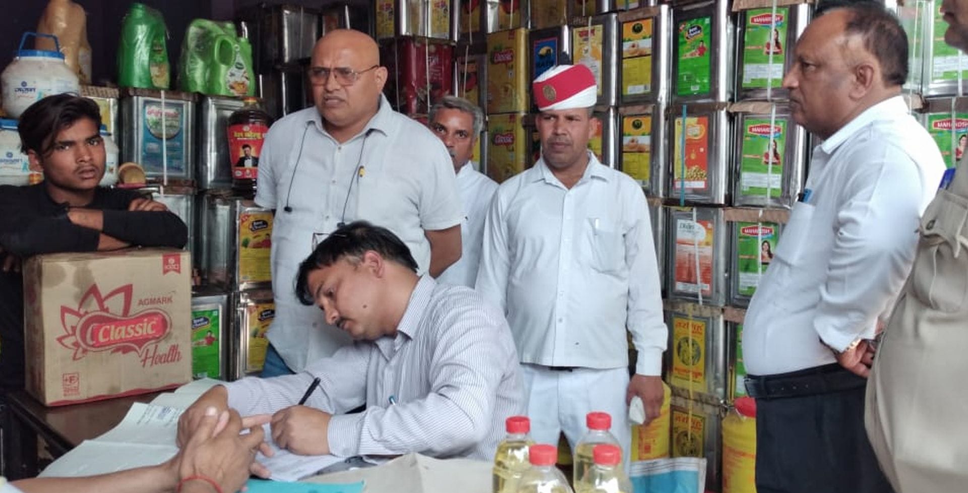शहर में नेहरू चौक स्थित एक दुकान पर छापा मारते एसडीएम सदर एसपी वर्मा, सहायक आयुक्त खाद्य चंद्रशेख