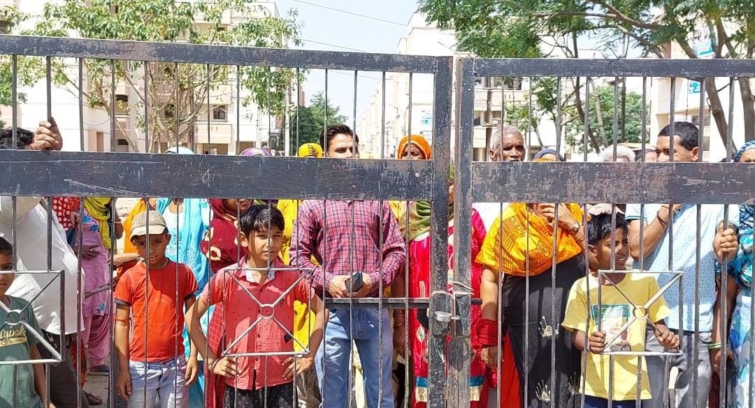हाउसिंग बोर्ड फ्लैटों के गेट पर ताला लगाकर खड़े लोग। हाउसिंग बोर्ड फ्लैटों के गेट पर ताला लगाकर खड़े लोग।